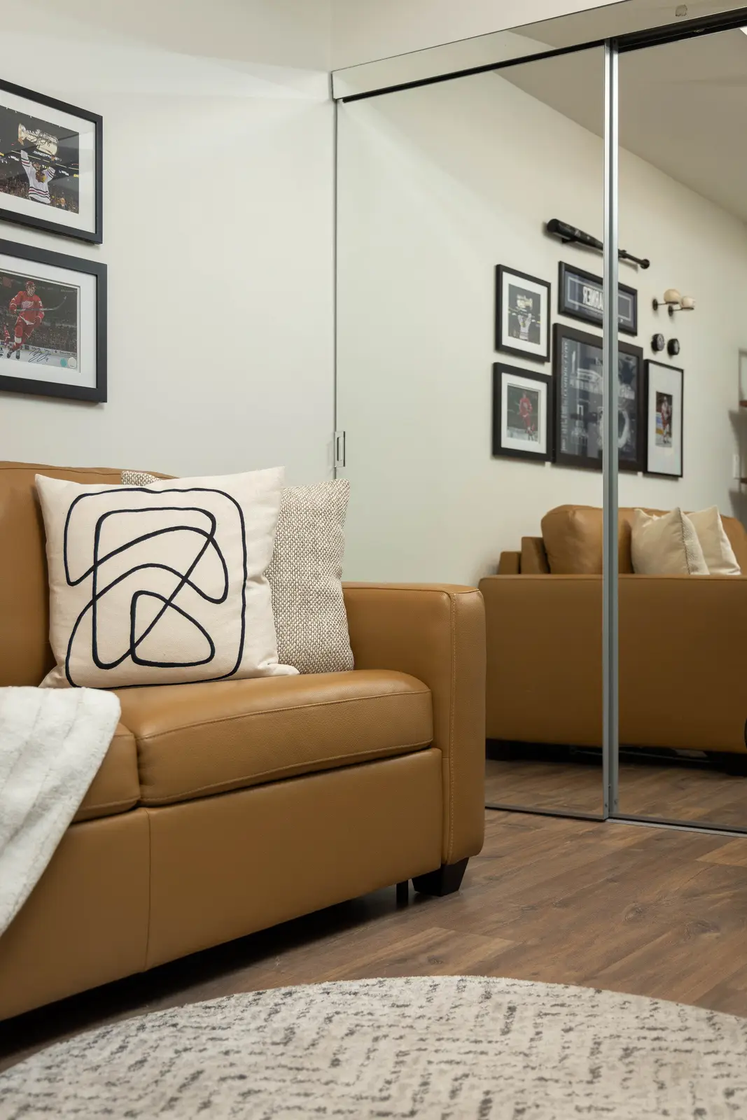 Interior of a Queen West condo in Toronto, with a grey sectional, a white kitchen, and black counters.