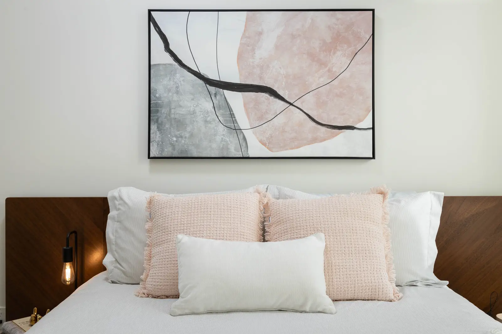 Interior of a Queen West condo in Toronto, with a grey sectional, a white kitchen, and black counters.