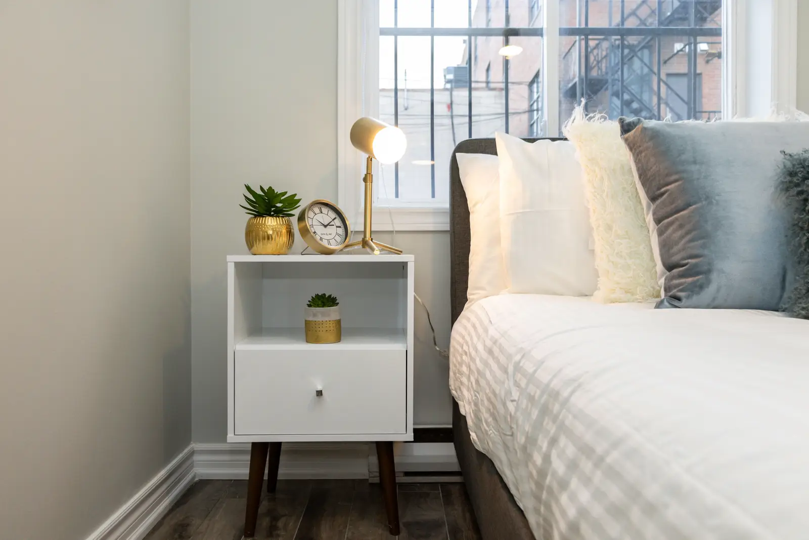 Interior of an apartment on Clinton Street in Toronto, with a blue sofa, a yellow chair, and a white kitchen.