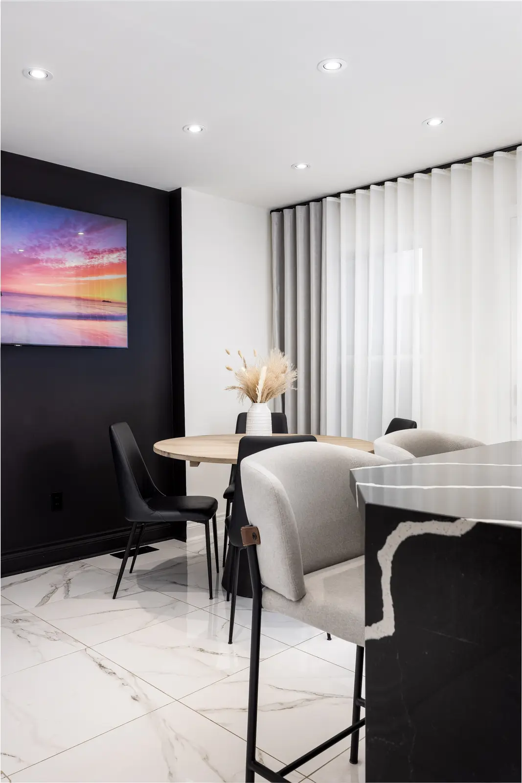 Interior of an Oakville house, with a dark dining table, light wood floors, and a white living room.