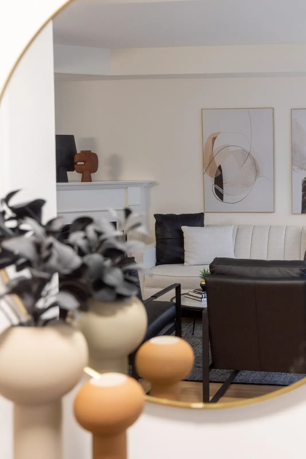 Interior of an Oakville house, with a dark dining table, light wood floors, and a white living room.