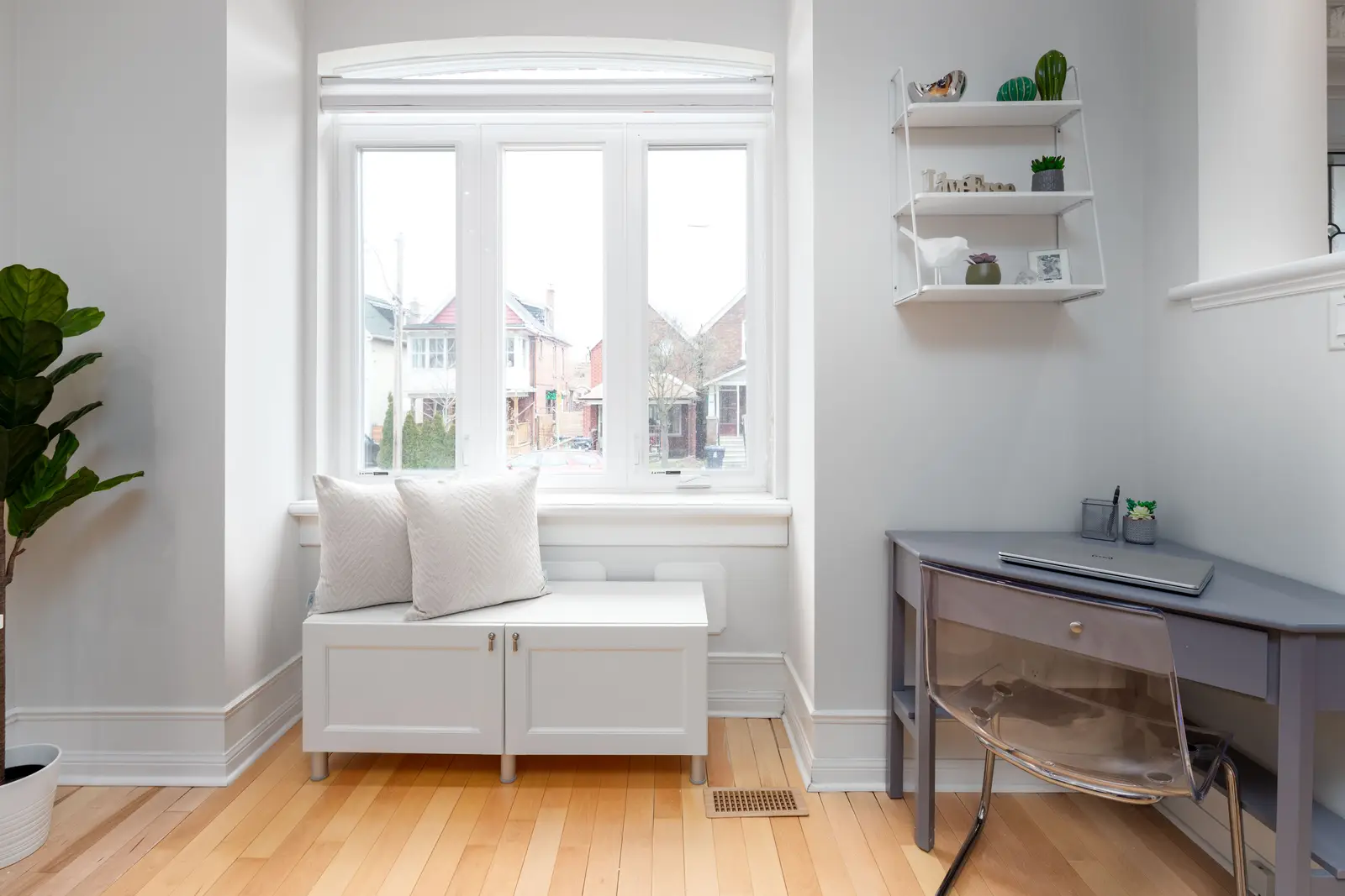 Interior of a Toronto house, with light walls, a wood kitchen, and a grey sofa.