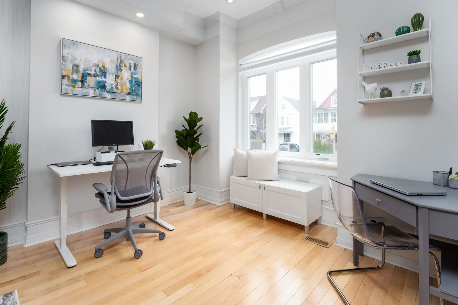 Interior of a Toronto house, with light walls, a wood kitchen, and a grey sofa.
