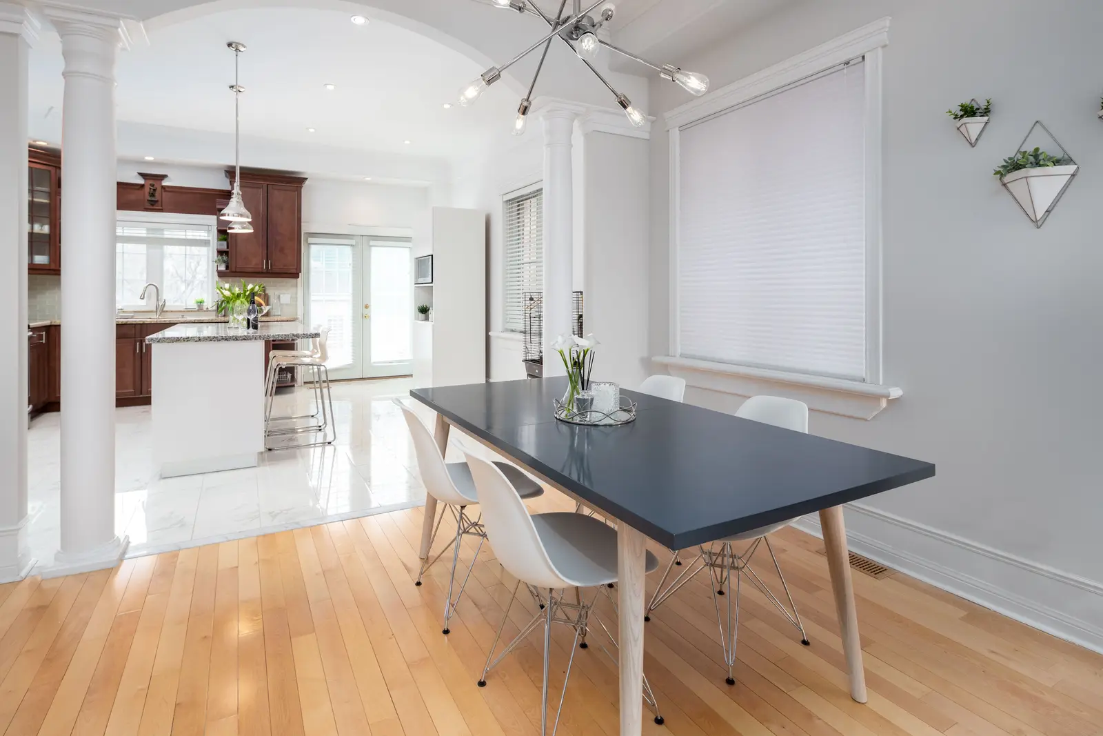 Interior of a Toronto house, with light walls, a wood kitchen, and a grey sofa.