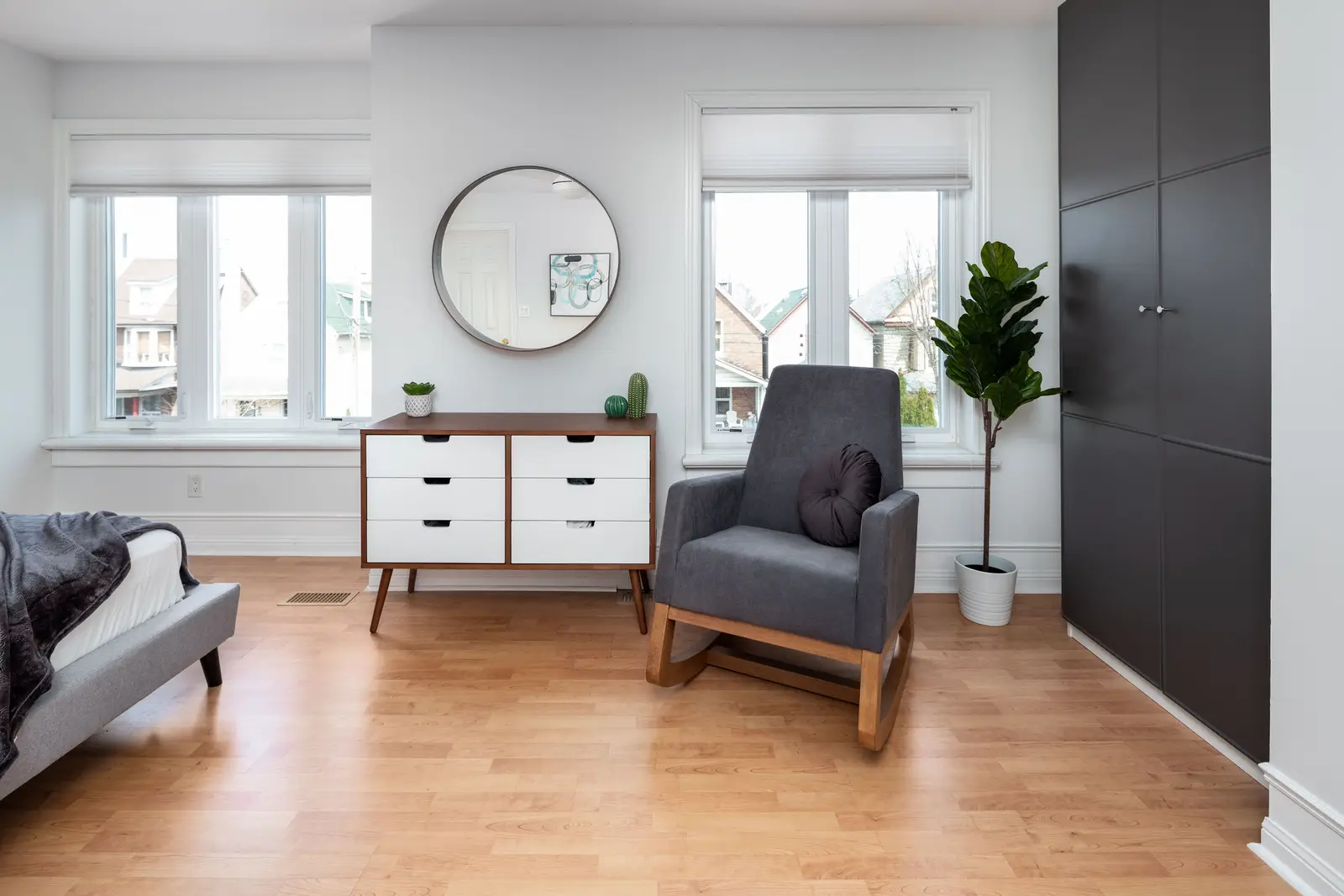 Interior of a Toronto house, with light walls, a wood kitchen, and a grey sofa.