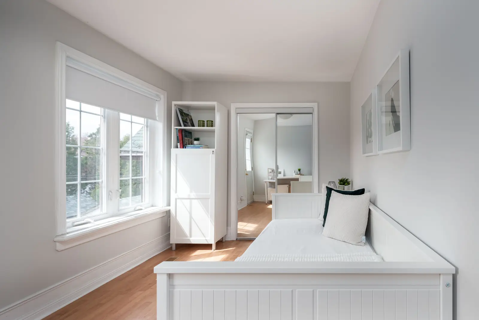 Interior of a Toronto house, with light walls, a wood kitchen, and a grey sofa.