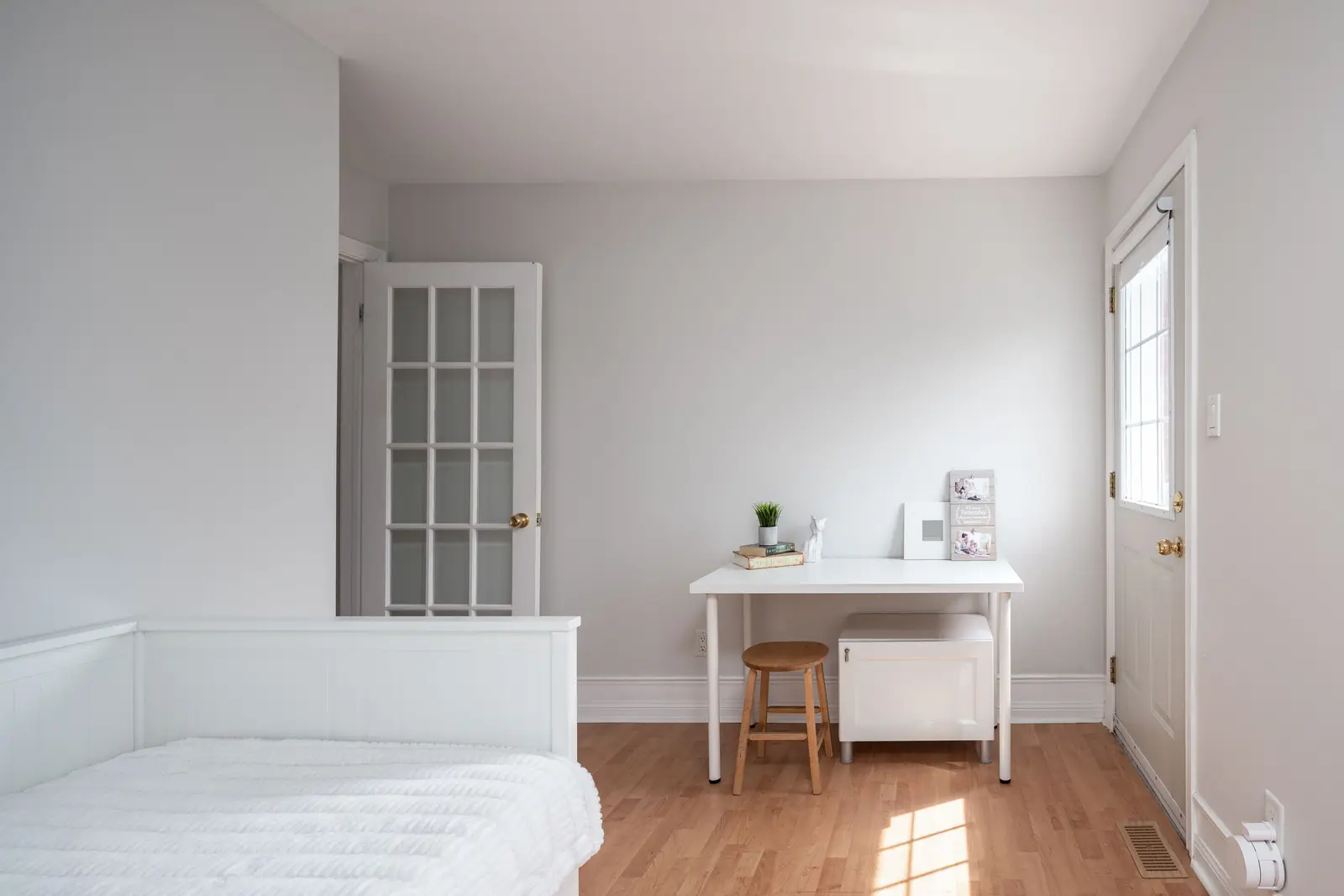 Interior of a Toronto house, with light walls, a wood kitchen, and a grey sofa.