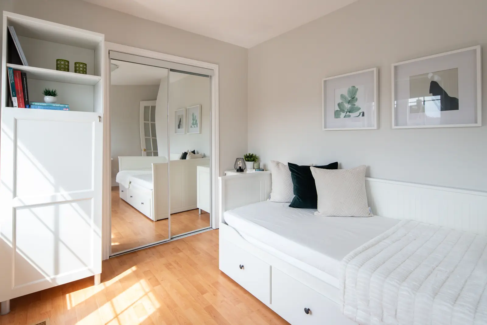 Interior of a Toronto house, with light walls, a wood kitchen, and a grey sofa.