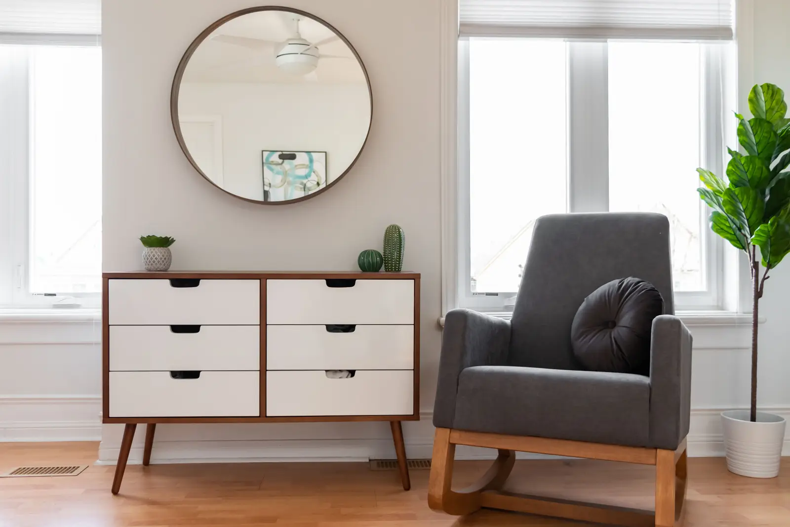 Interior of a Toronto house, with light walls, a wood kitchen, and a grey sofa.
