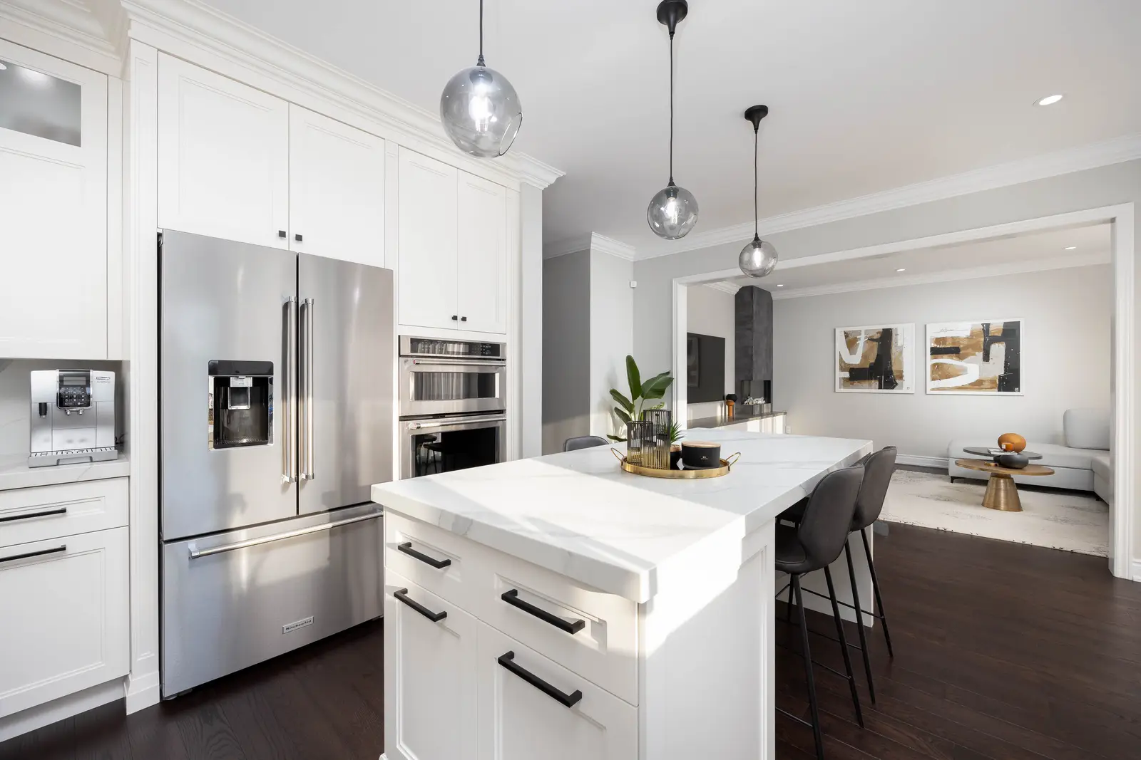 Interior of a Vaughan house, with white cabinetry, dark wood floors, and marble.
