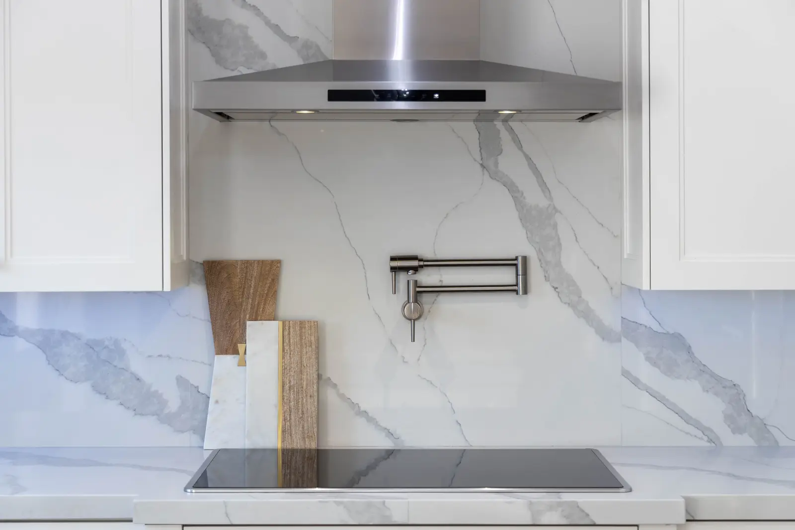 Interior of a Vaughan house, with white cabinetry, dark wood floors, and marble.