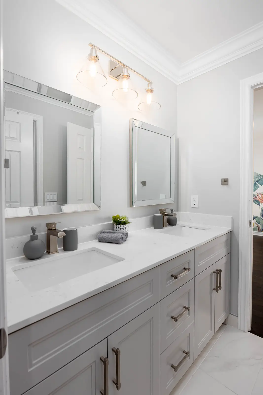 Interior of a Vaughan house, with white cabinetry, dark wood floors, and marble.