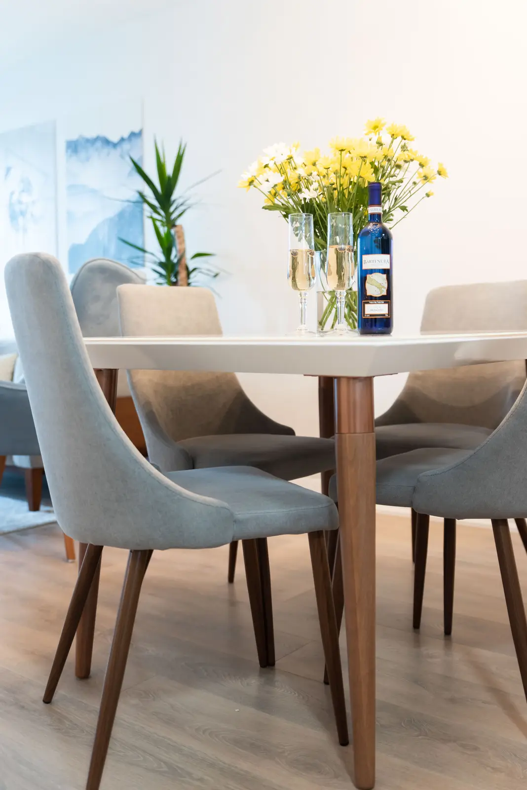 Interior of a North York condo, with a pale sofa, a white kitchen, and light wood floors.