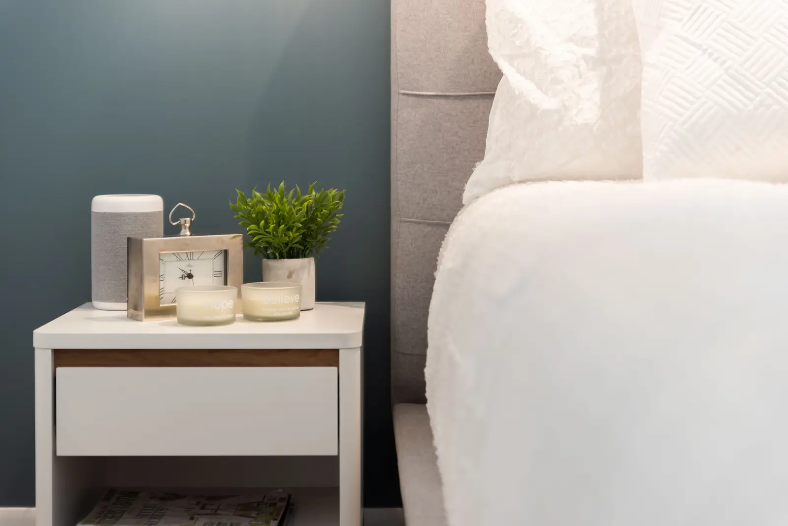 Interior of a North York condo, with a pale sofa, a white kitchen, and light wood floors.