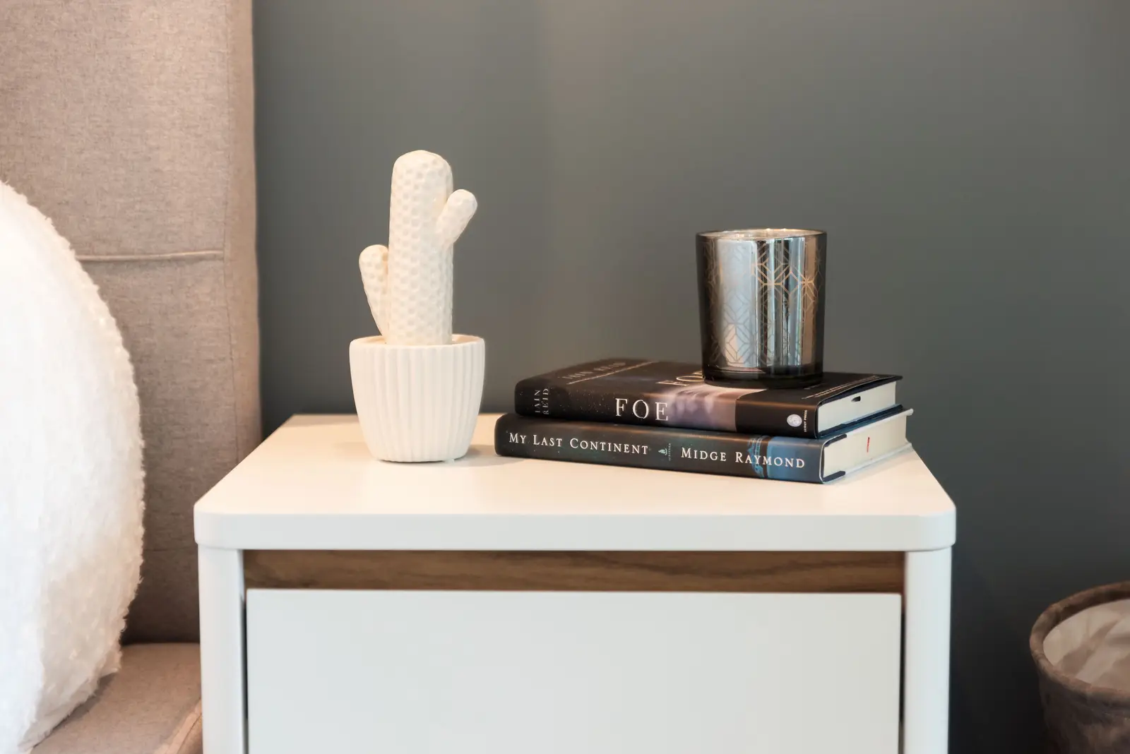 Interior of a North York condo, with a pale sofa, a white kitchen, and light wood floors.