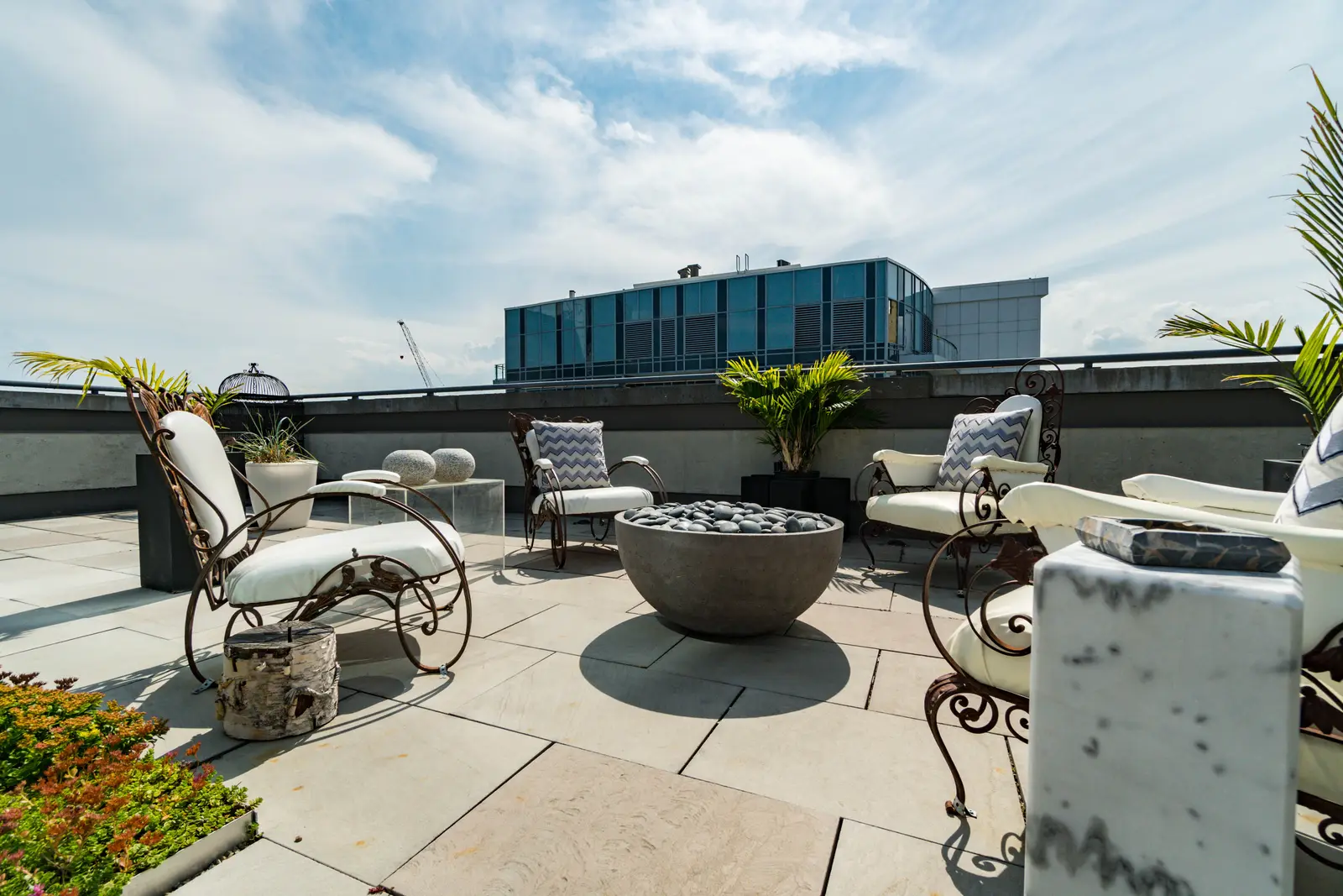 Interior of a condo on Adelaide Street West in Toronto, with purple chairs, a white living room, and the skyline beyond the glass.