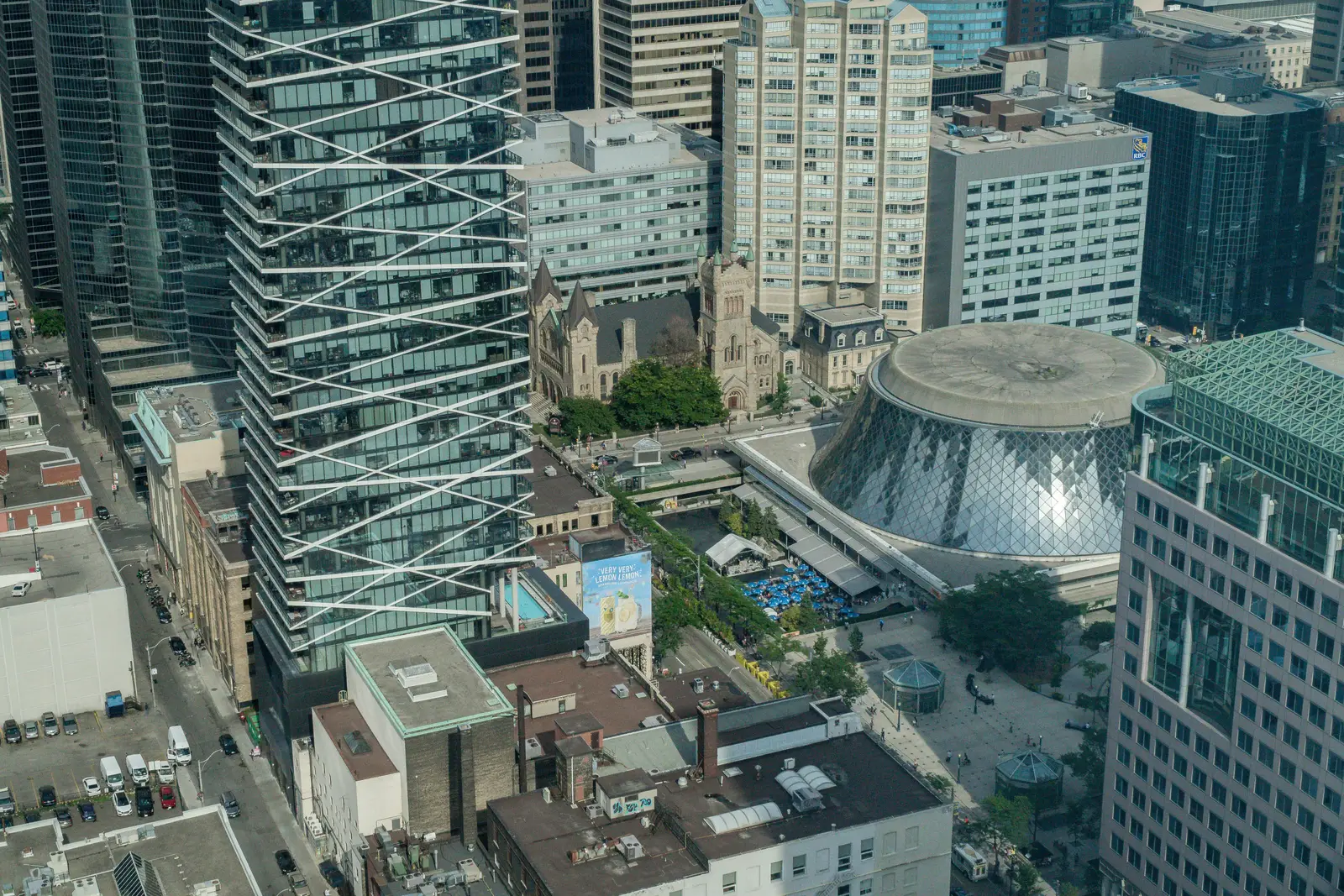 Interior of a condo on Adelaide Street West in Toronto, with purple chairs, a white living room, and the skyline beyond the glass.