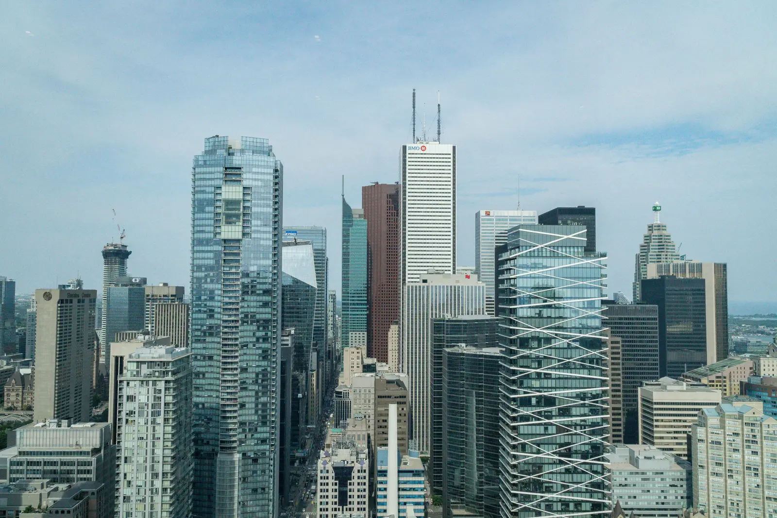 Interior of a condo on Adelaide Street West in Toronto, with purple chairs, a white living room, and the skyline beyond the glass.