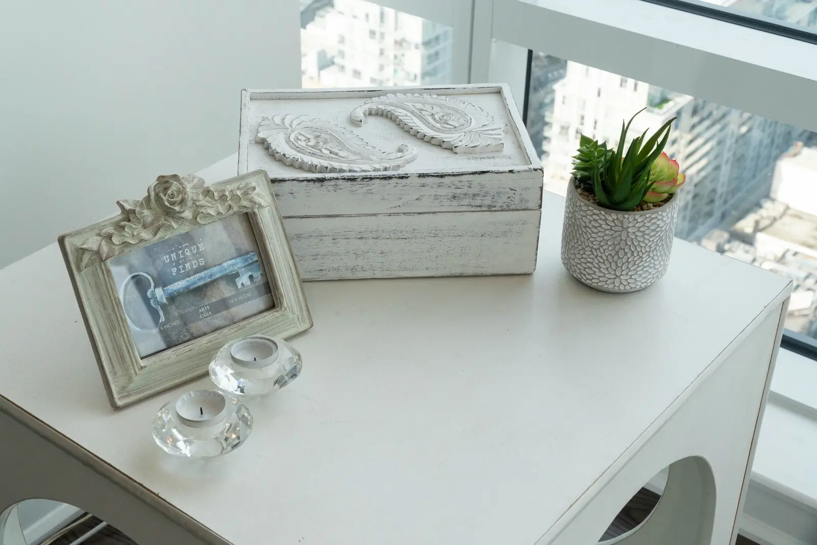 Interior of a condo on Adelaide Street West in Toronto, with purple chairs, a white living room, and the skyline beyond the glass.