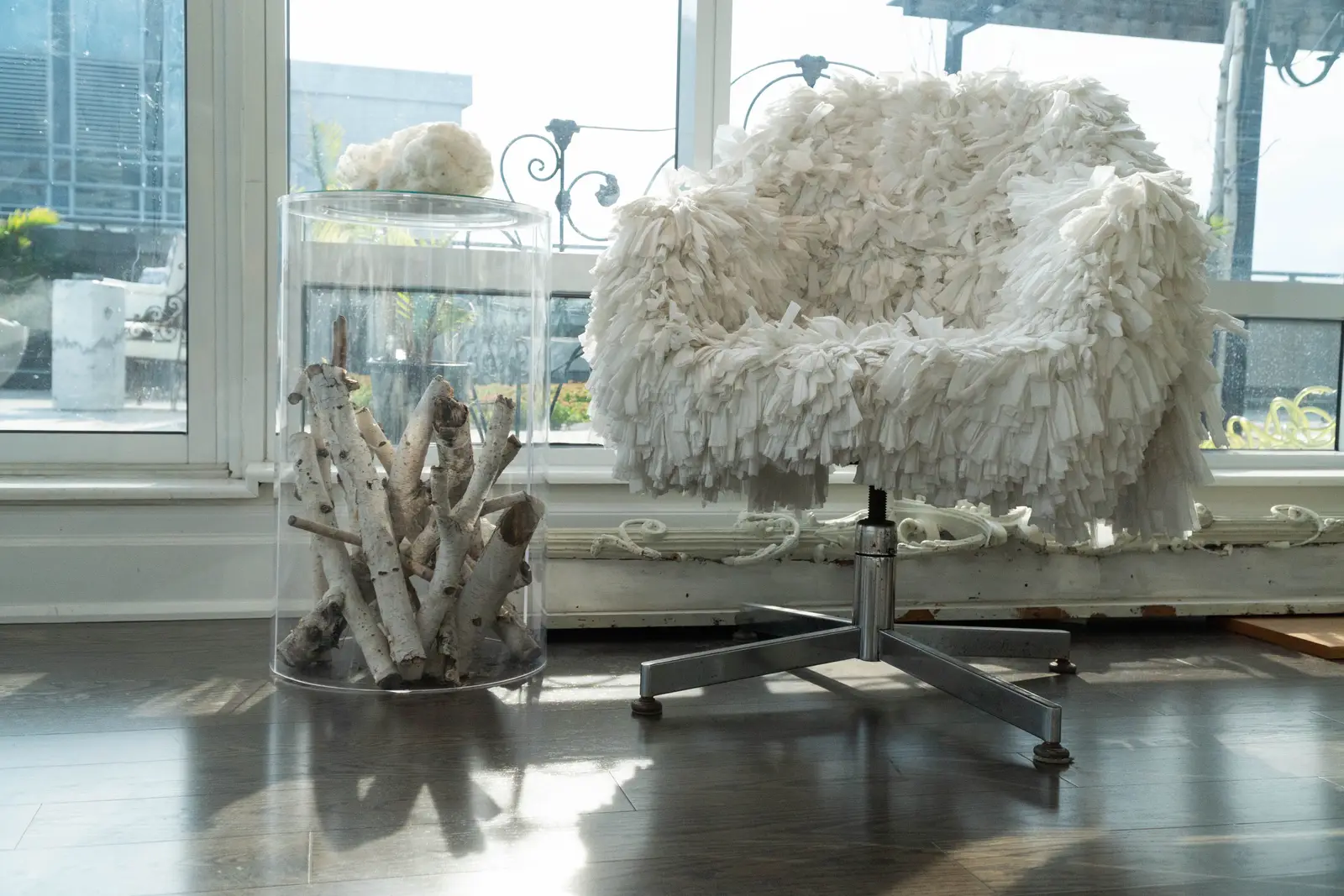 Interior of a condo on Adelaide Street West in Toronto, with purple chairs, a white living room, and the skyline beyond the glass.