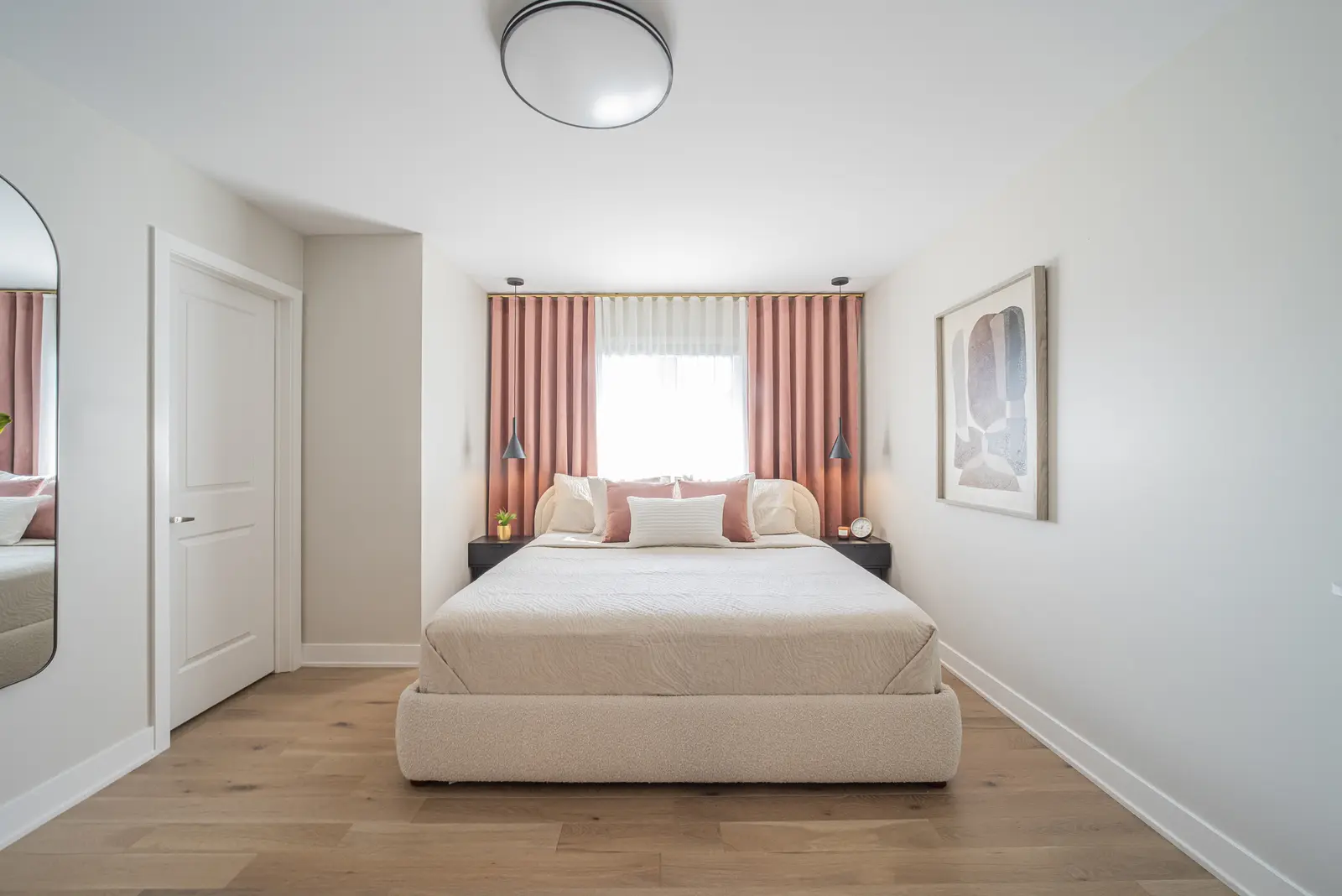 Interior of a house on Disney Court in Whitby, with a light living room, a white kitchen, and a bedroom in dusty rose.