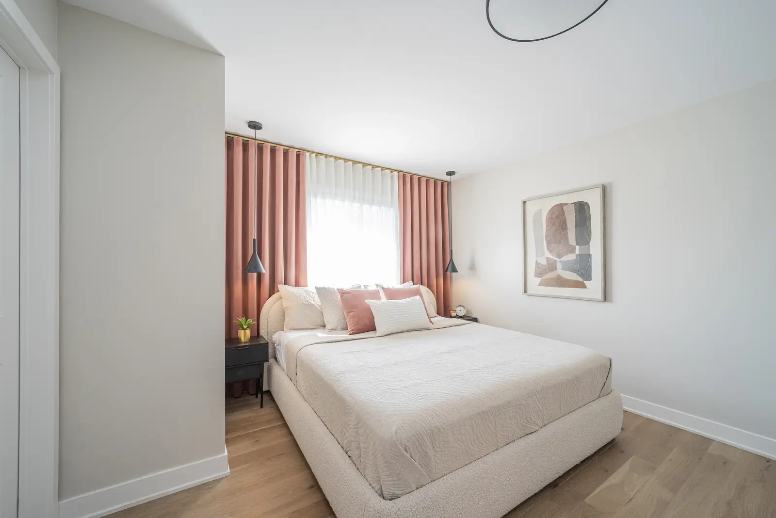 Interior of a house on Disney Court in Whitby, with a light living room, a white kitchen, and a bedroom in dusty rose.