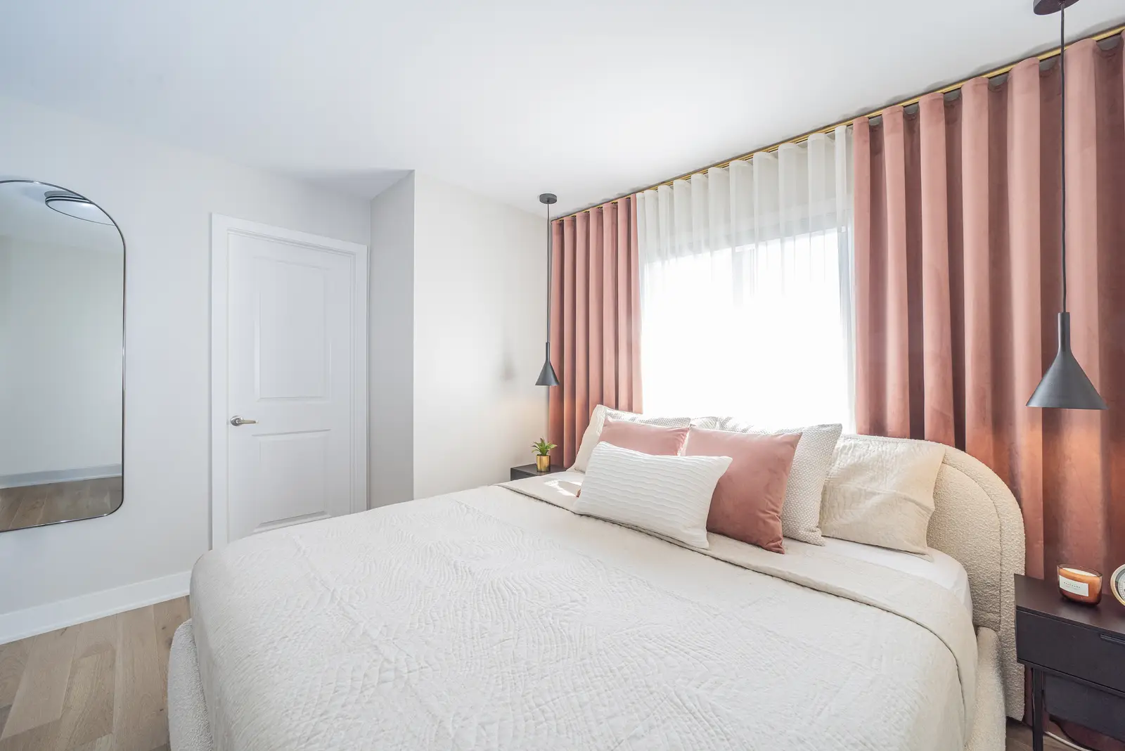 Interior of a house on Disney Court in Whitby, with a light living room, a white kitchen, and a bedroom in dusty rose.