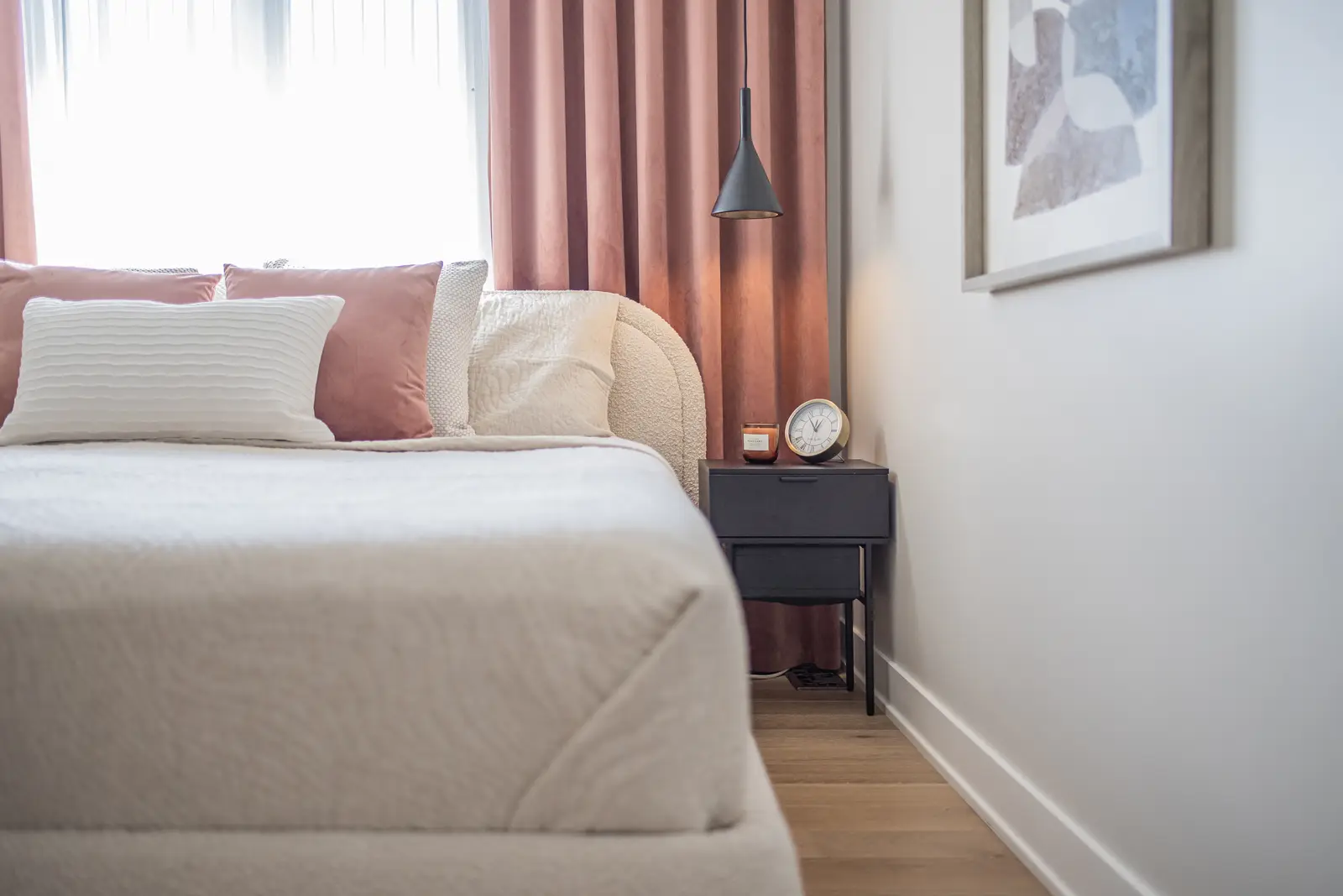 Interior of a house on Disney Court in Whitby, with a light living room, a white kitchen, and a bedroom in dusty rose.