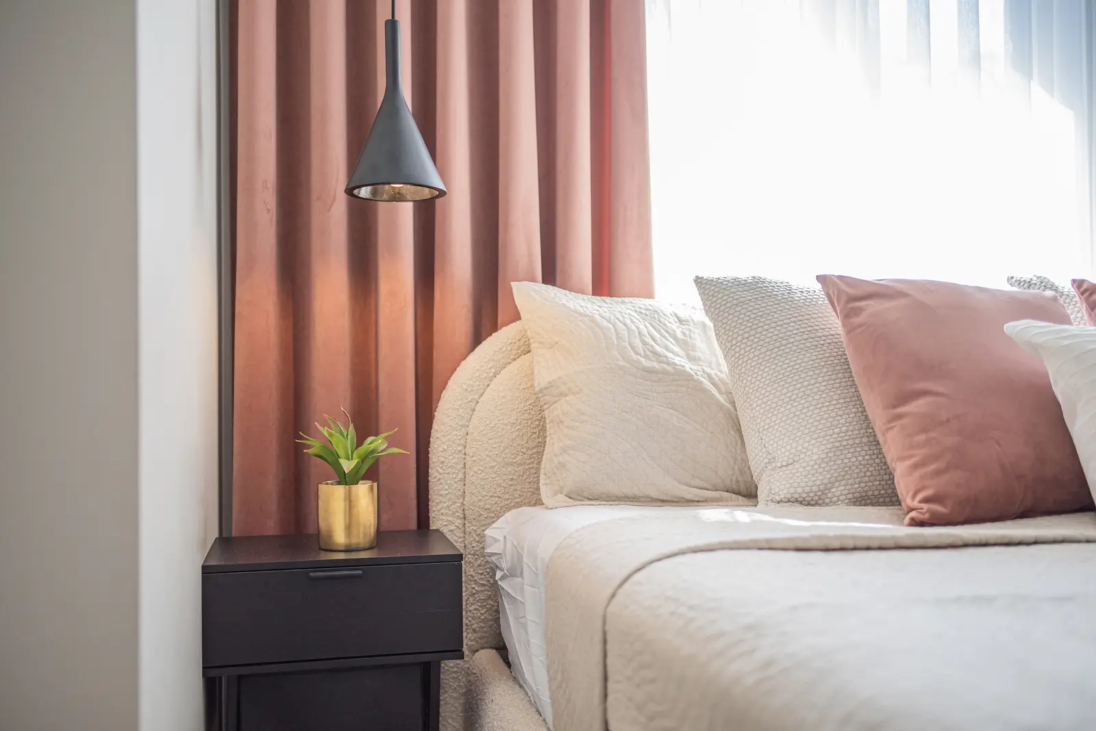 Interior of a house on Disney Court in Whitby, with a light living room, a white kitchen, and a bedroom in dusty rose.