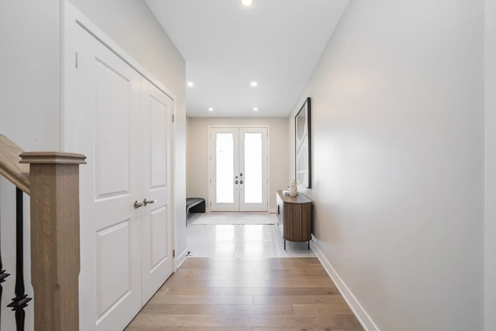 Interior of a house on Disney Court in Whitby, with a light living room, a white kitchen, and a bedroom in dusty rose.