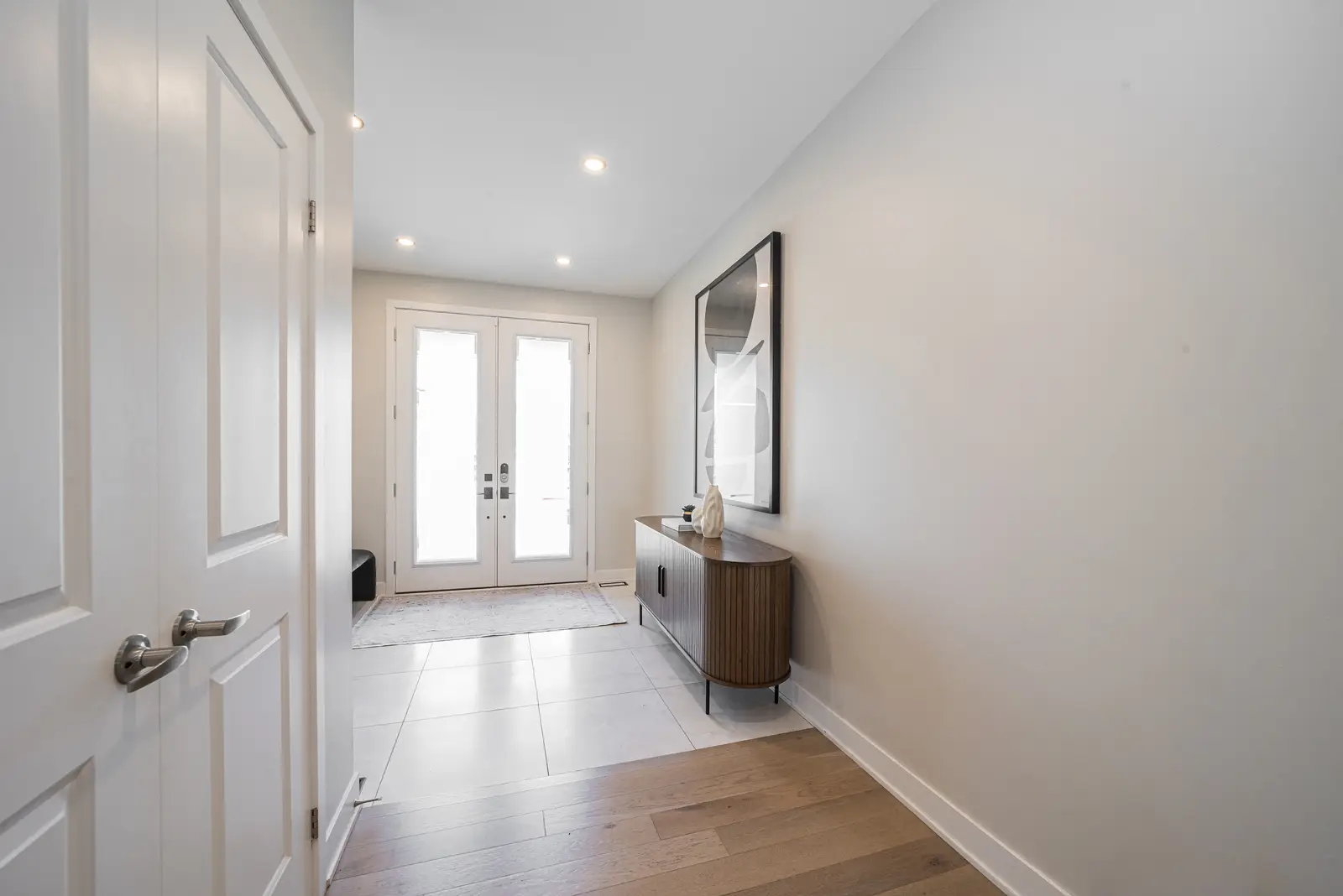 Interior of a house on Disney Court in Whitby, with a light living room, a white kitchen, and a bedroom in dusty rose.