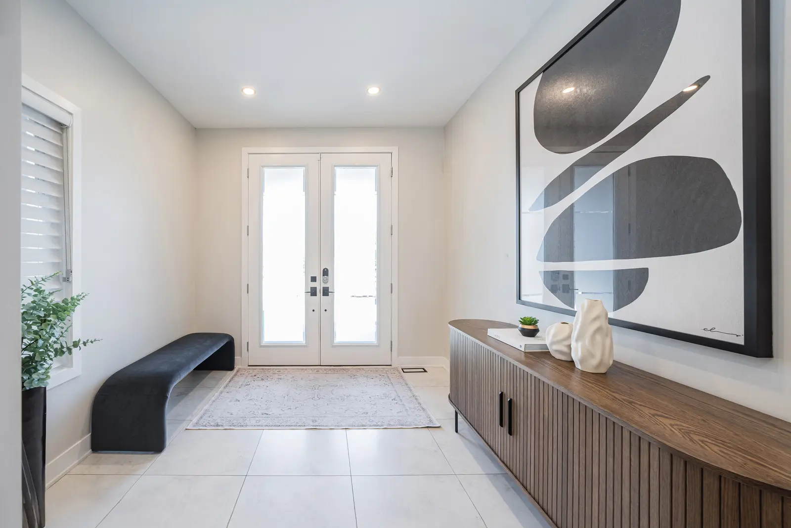 Interior of a house on Disney Court in Whitby, with a light living room, a white kitchen, and a bedroom in dusty rose.