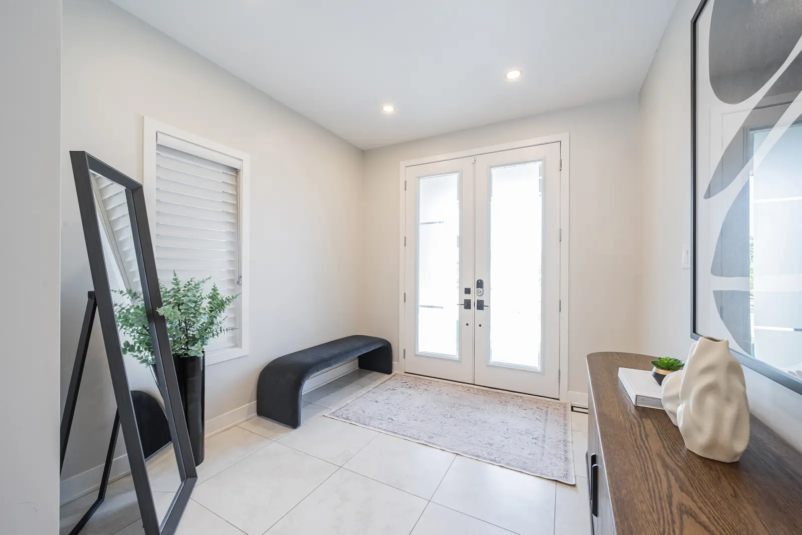Interior of a house on Disney Court in Whitby, with a light living room, a white kitchen, and a bedroom in dusty rose.