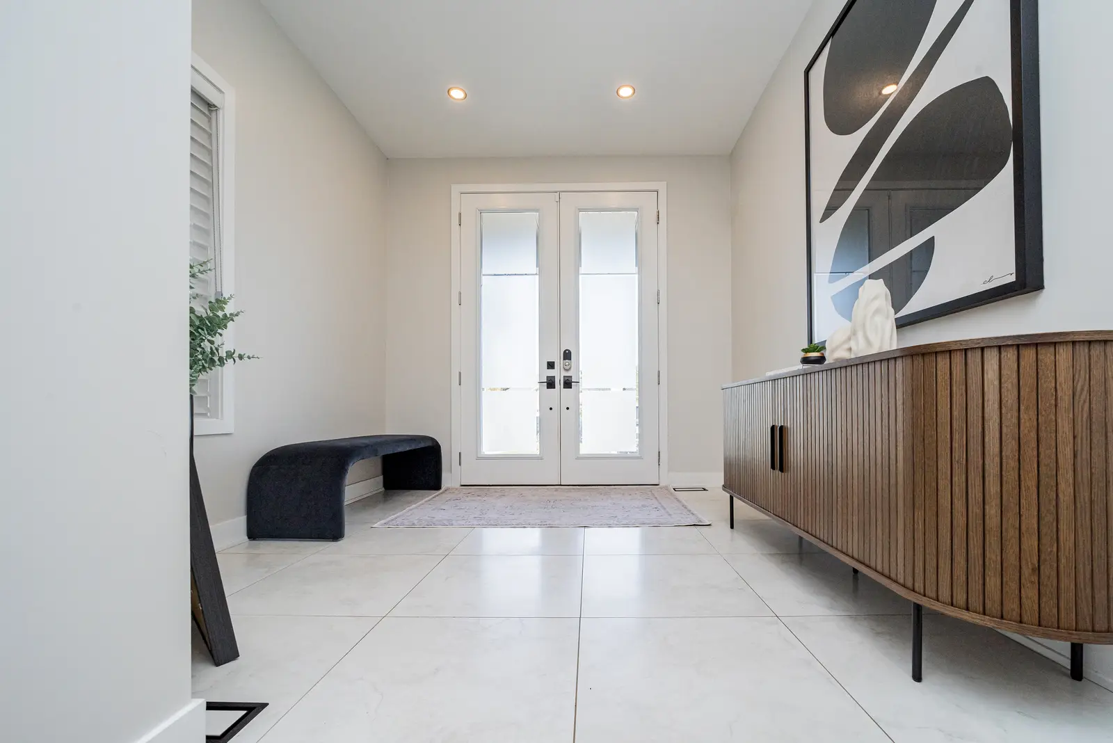 Interior of a house on Disney Court in Whitby, with a light living room, a white kitchen, and a bedroom in dusty rose.