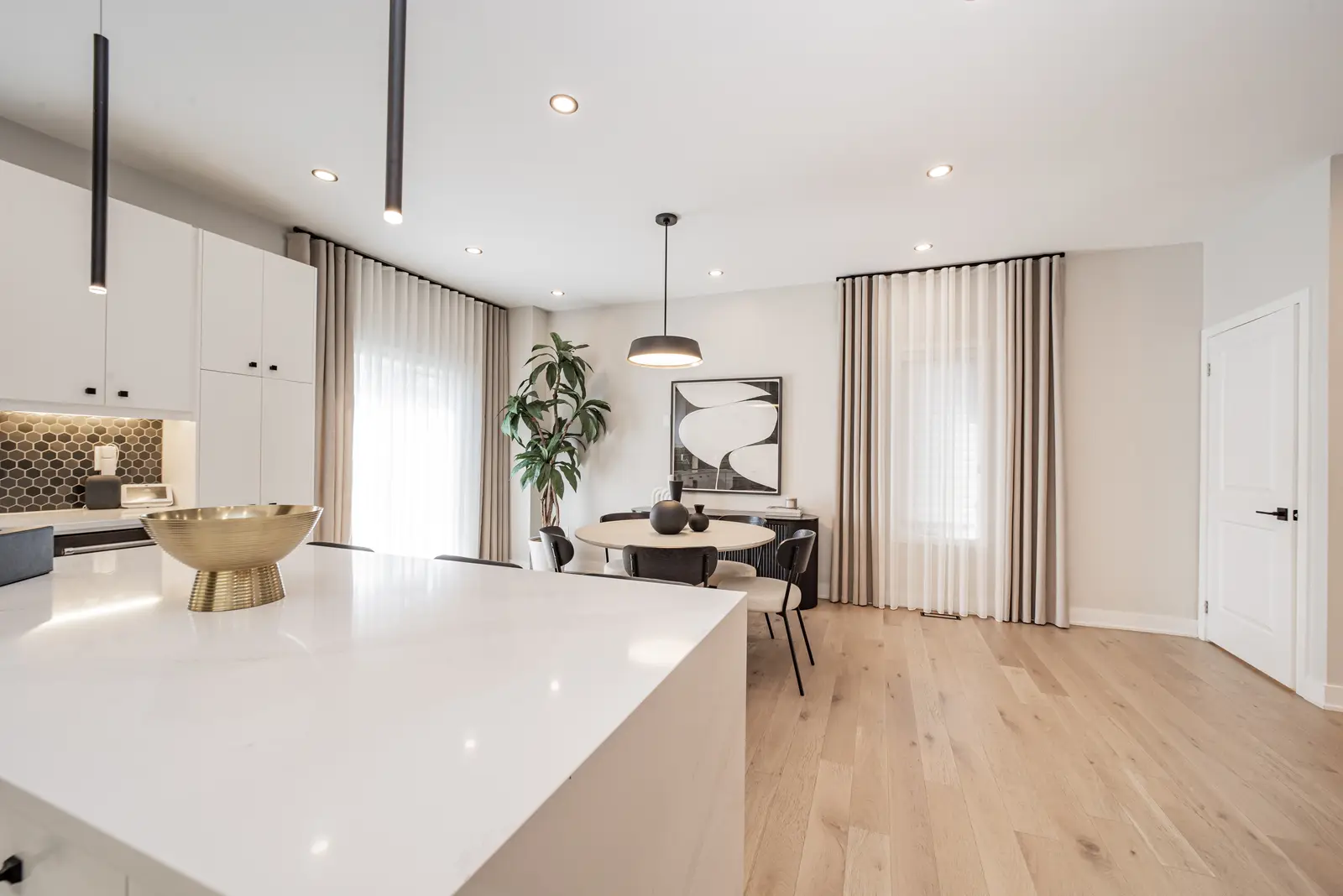 Interior of a house on Disney Court in Whitby, with a light living room, a white kitchen, and a bedroom in dusty rose.