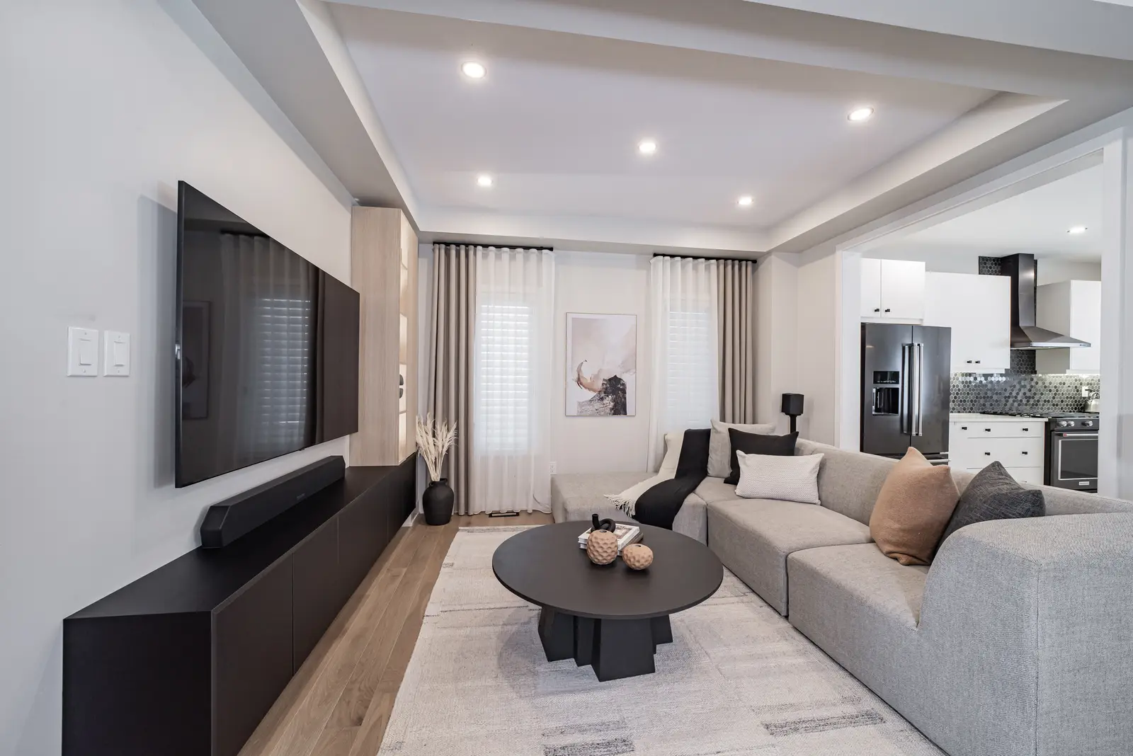 Interior of a house on Disney Court in Whitby, with a light living room, a white kitchen, and a bedroom in dusty rose.