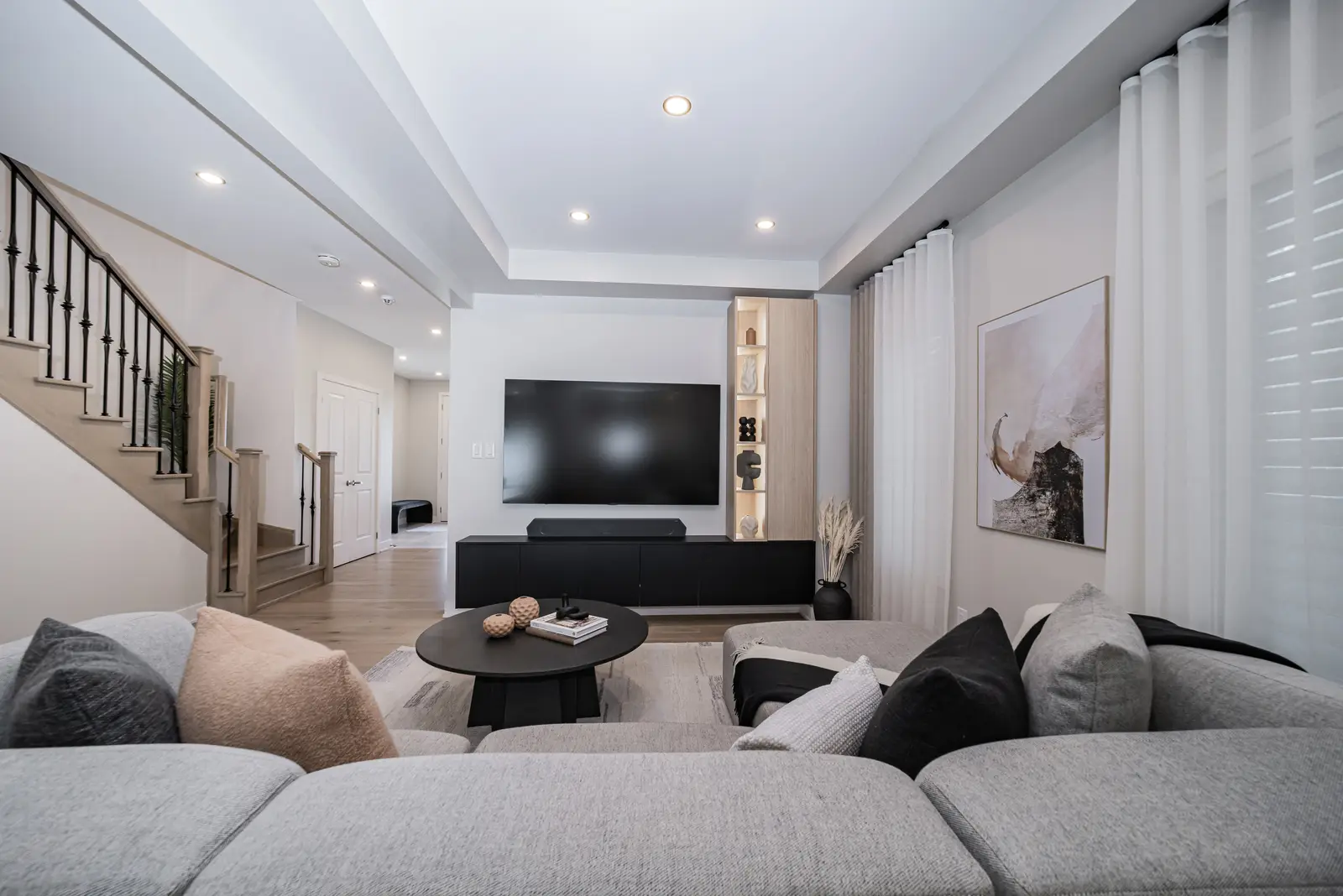 Interior of a house on Disney Court in Whitby, with a light living room, a white kitchen, and a bedroom in dusty rose.
