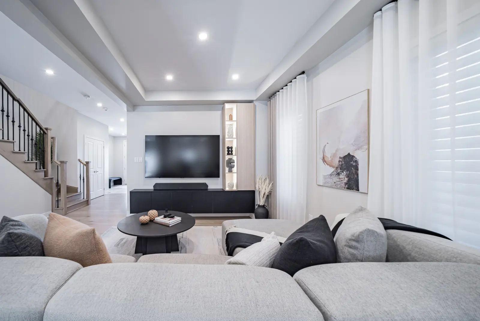 Interior of a house on Disney Court in Whitby, with a light living room, a white kitchen, and a bedroom in dusty rose.