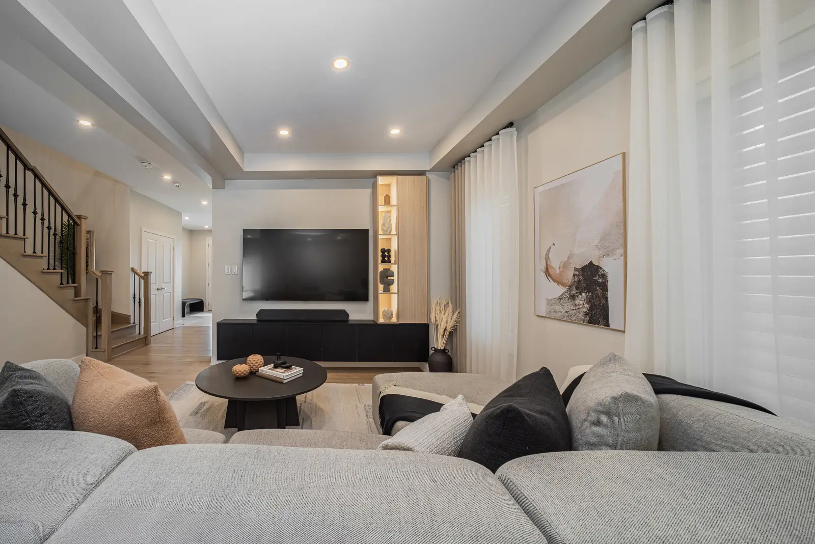 Interior of a house on Disney Court in Whitby, with a light living room, a white kitchen, and a bedroom in dusty rose.