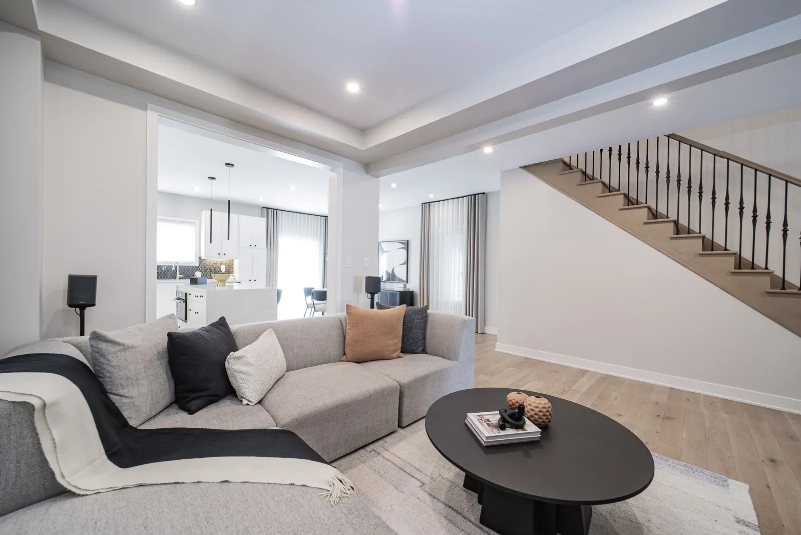 Interior of a house on Disney Court in Whitby, with a light living room, a white kitchen, and a bedroom in dusty rose.