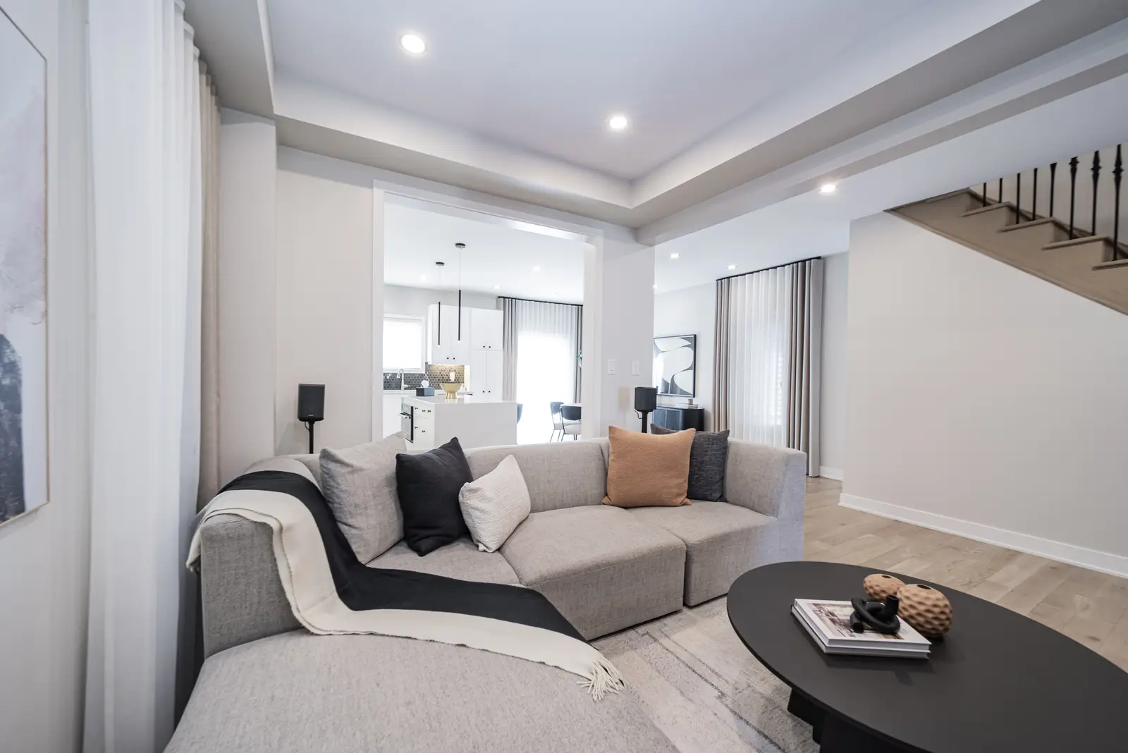 Interior of a house on Disney Court in Whitby, with a light living room, a white kitchen, and a bedroom in dusty rose.