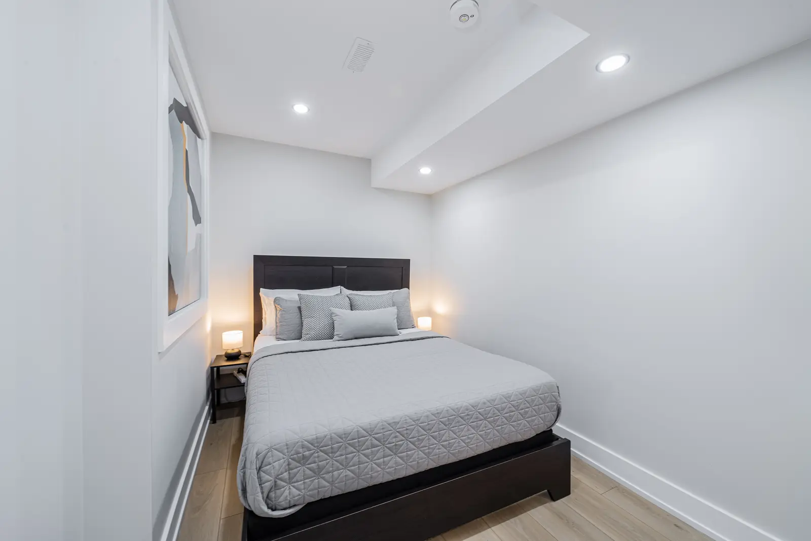 Interior of a house on Disney Court in Whitby, with a light living room, a white kitchen, and a bedroom in dusty rose.