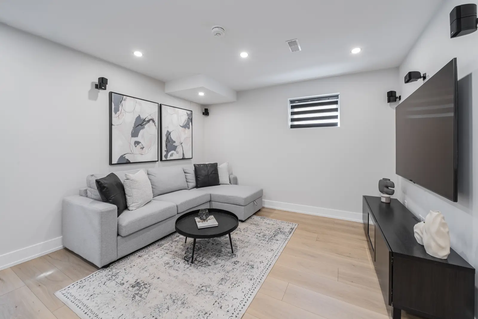 Interior of a house on Disney Court in Whitby, with a light living room, a white kitchen, and a bedroom in dusty rose.