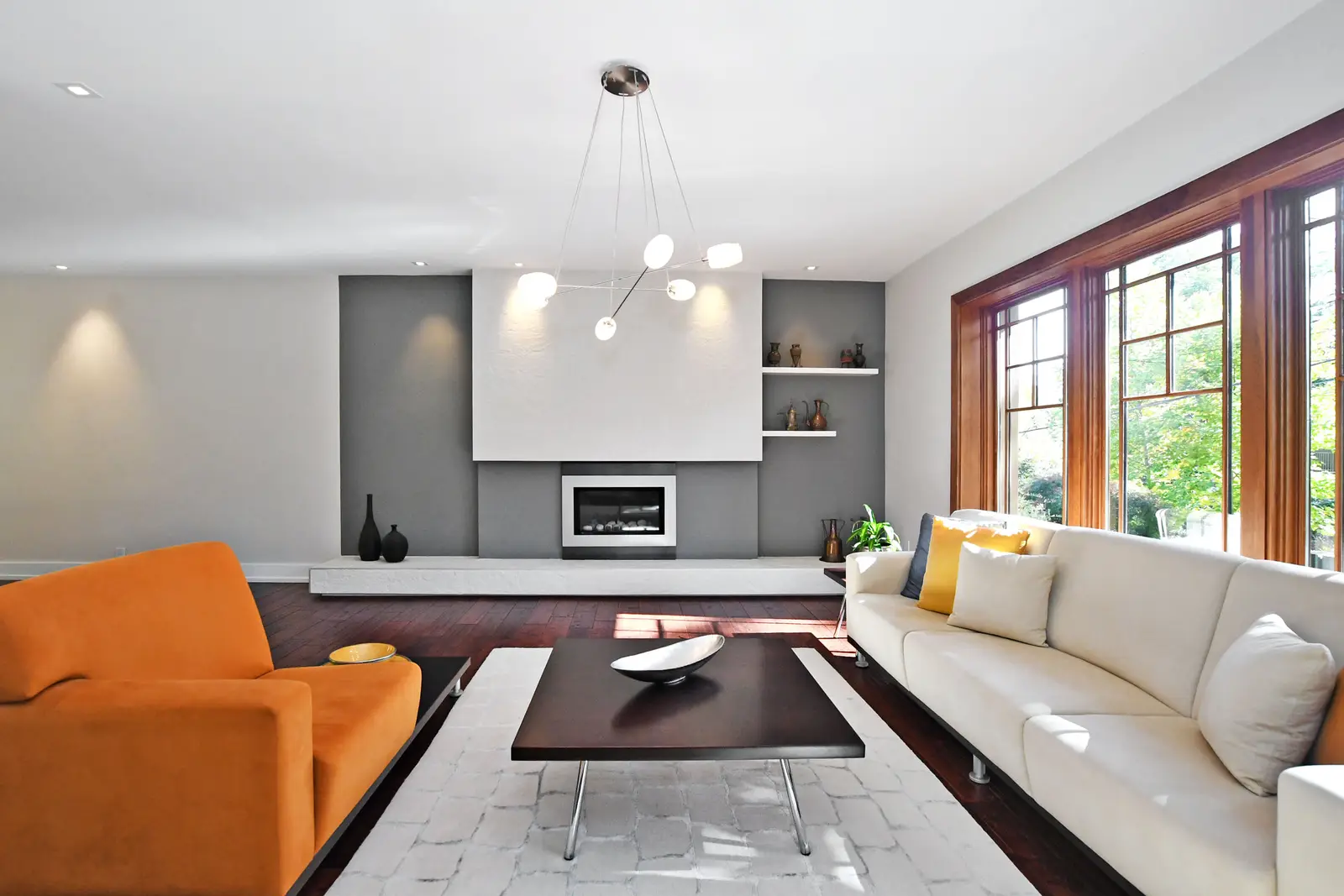 Interior of a house on Plymbridge Road in North York, with wood floors, a white kitchen, and windows onto the trees.