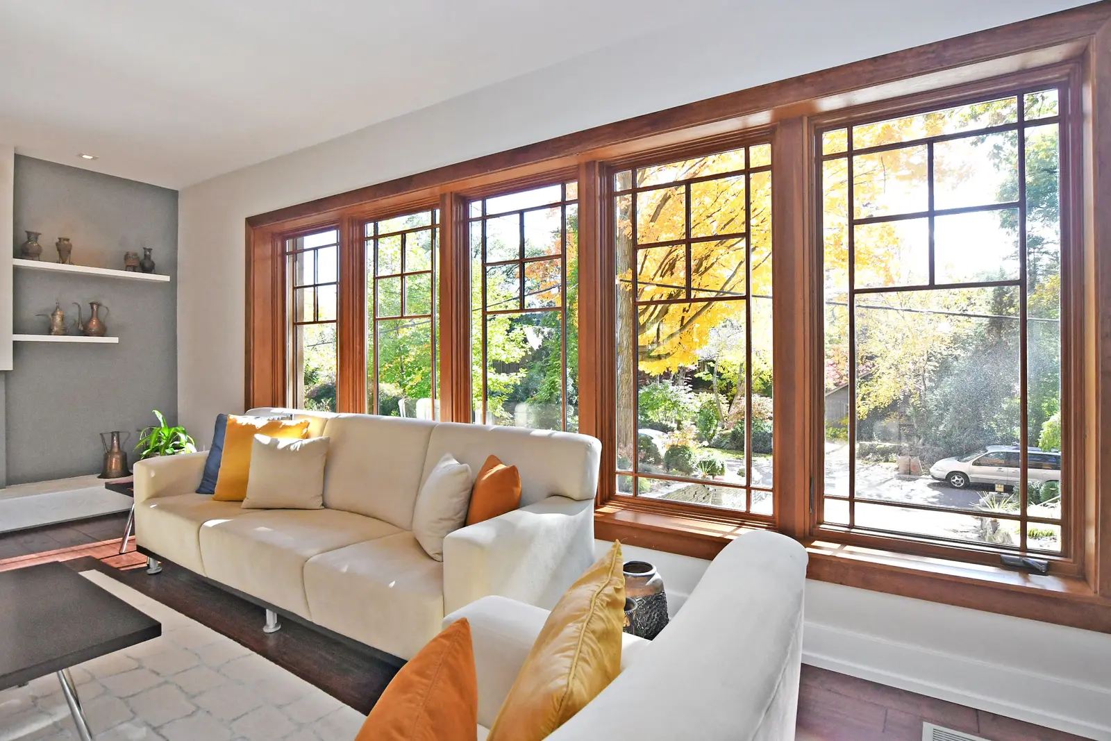 Interior of a house on Plymbridge Road in North York, with wood floors, a white kitchen, and windows onto the trees.