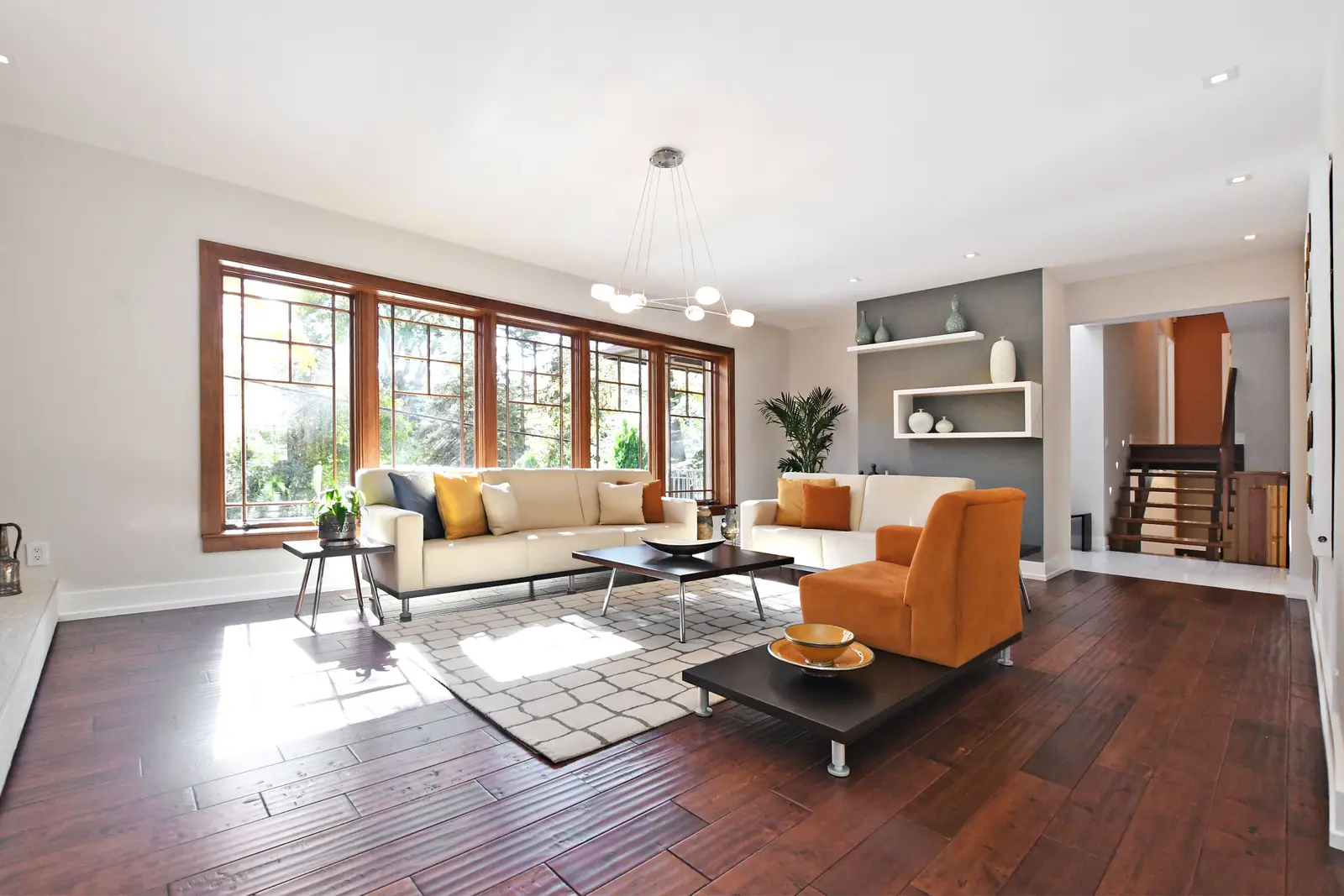 Interior of a house on Plymbridge Road in North York, with wood floors, a white kitchen, and windows onto the trees.