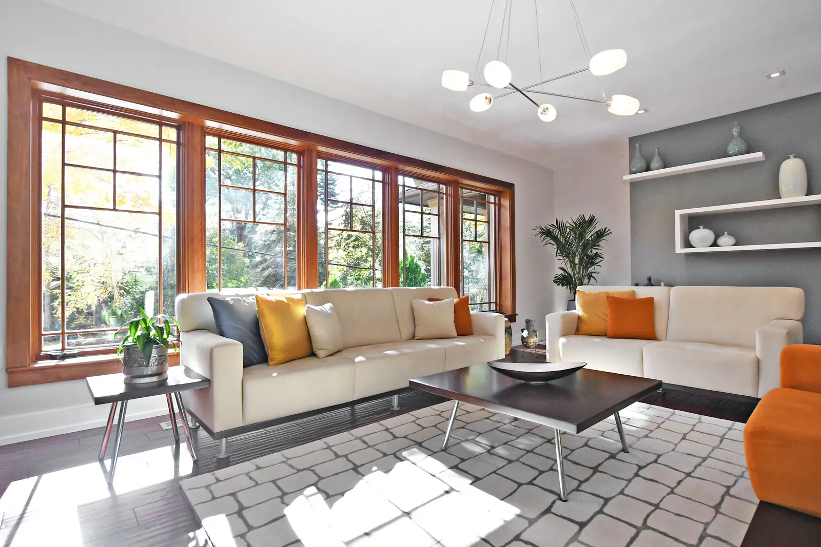 Interior of a house on Plymbridge Road in North York, with wood floors, a white kitchen, and windows onto the trees.