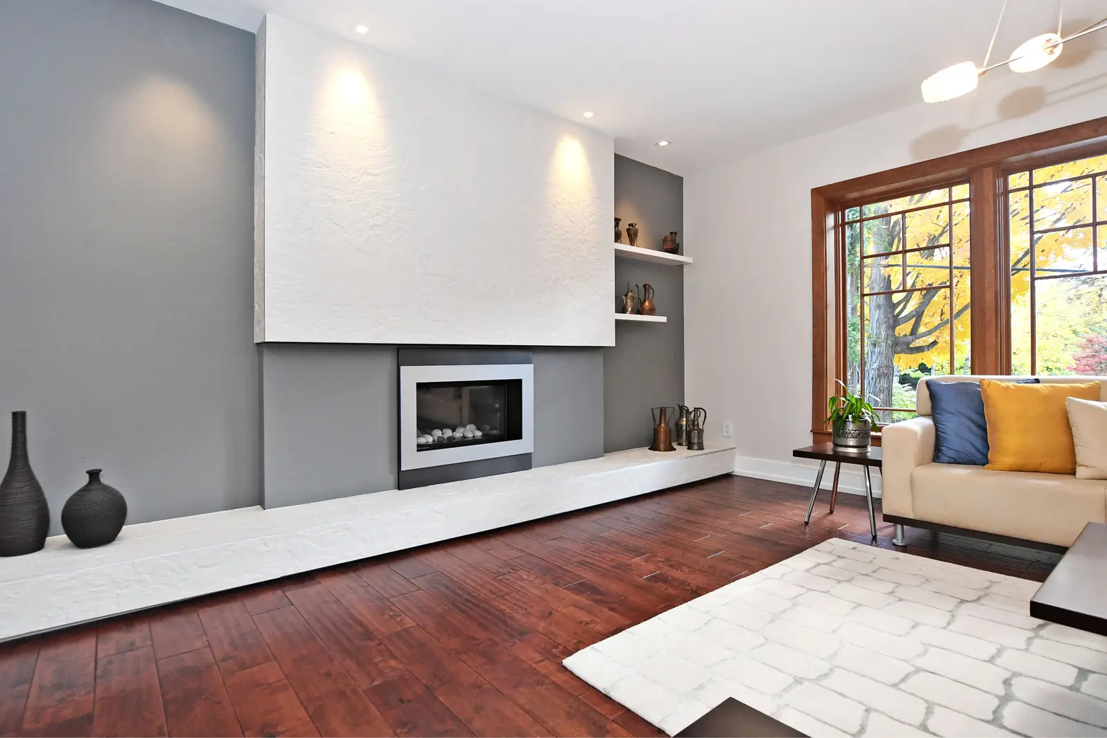 Interior of a house on Plymbridge Road in North York, with wood floors, a white kitchen, and windows onto the trees.
