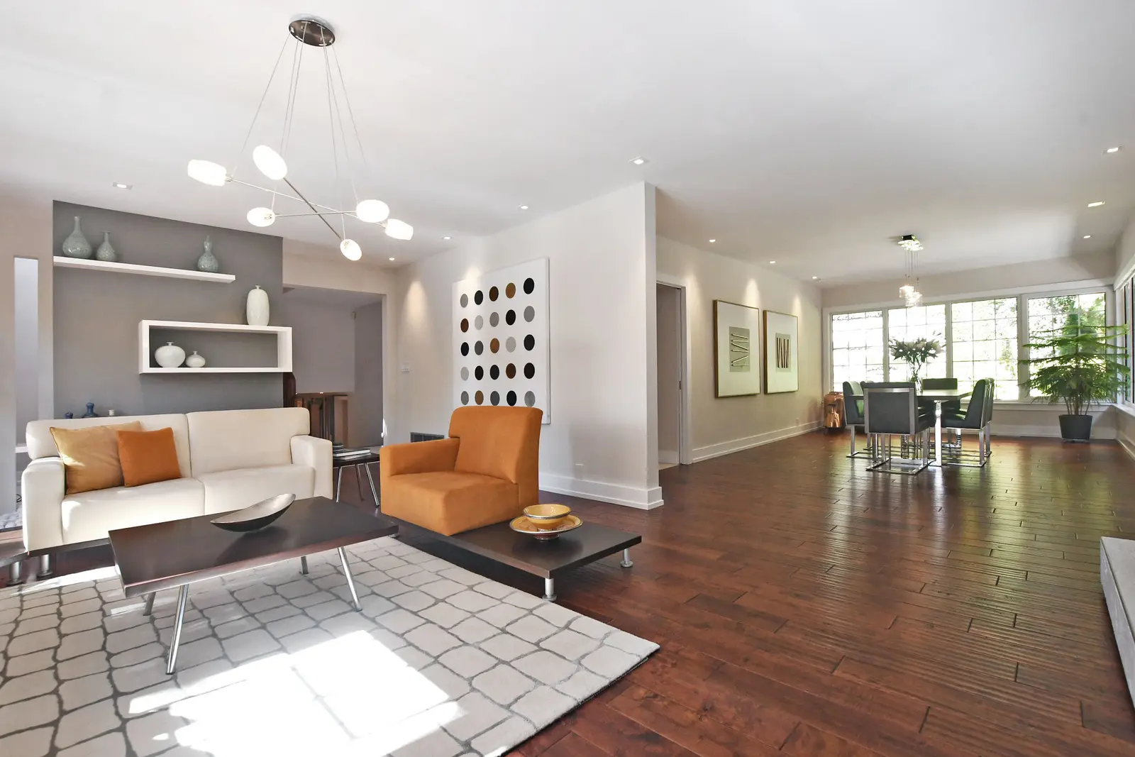 Interior of a house on Plymbridge Road in North York, with wood floors, a white kitchen, and windows onto the trees.