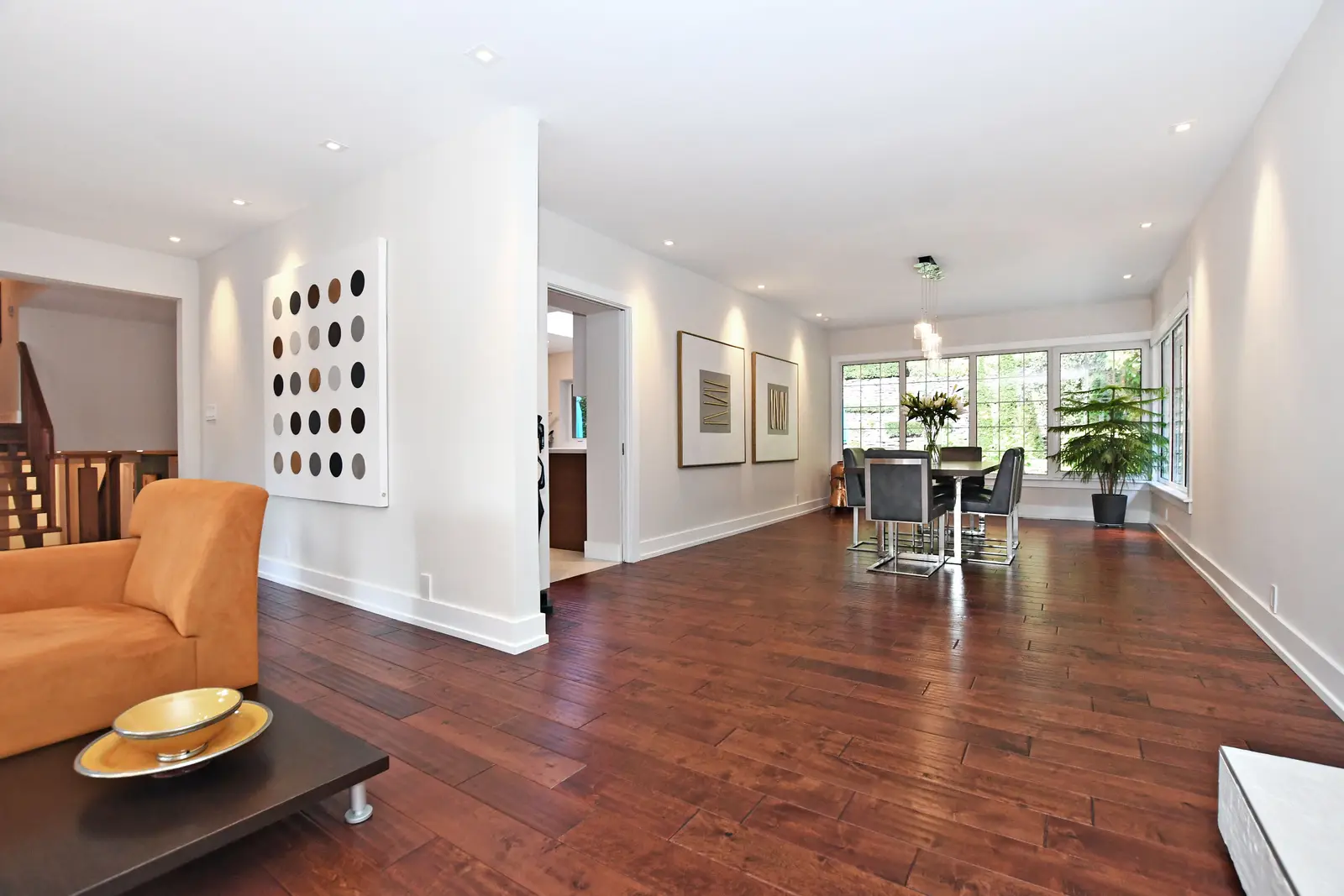 Interior of a house on Plymbridge Road in North York, with wood floors, a white kitchen, and windows onto the trees.